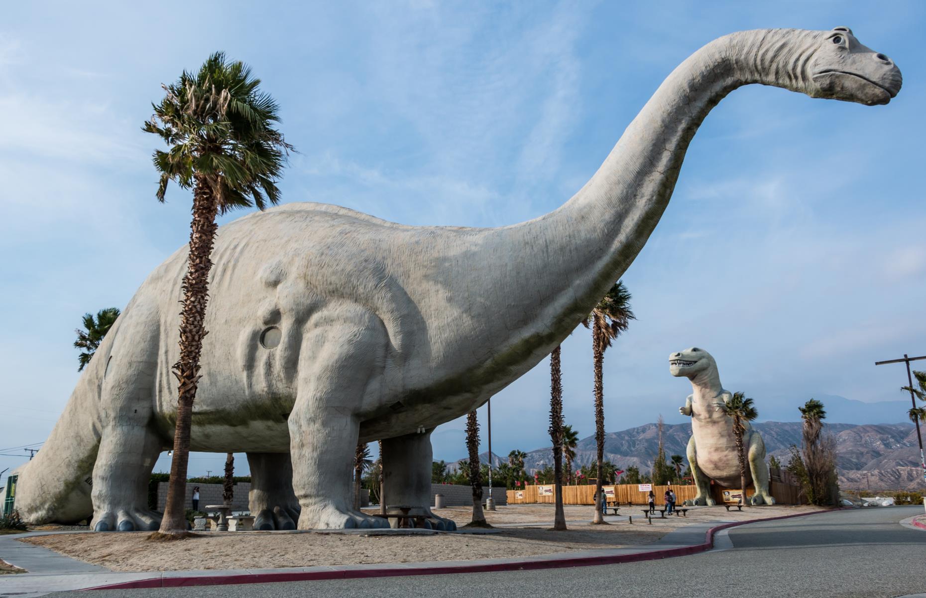 <p>The drive from city to city takes around one hour 45 minutes, but attractions en route tend to slow travelers down. There’s the Cabazon Dinosaurs (pictured), a quirky roadside amusement famed for its giant robotic dinosaurs. There’s also the San Gorgonio Pass, a particularly striking stretch of roadway with mountain views and a large wind farm. Palm Springs itself is famed for its resorts and its panorama-wielding aerial tramway (the tramway is temporarily closed – <a href="https://pstramway.com/">have a look at the website for updates</a>). </p>