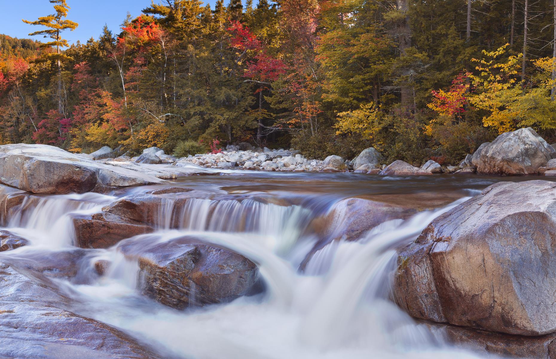 <p>Unsurprisingly, the route attracts plenty of leaf-peepers in fall, though it’s just as pretty in spring or summer, or when dusted with snow in winter. The road follows the path of the Swift River and hiking trails peel off the road and into the forest – top stop offs include Lower Falls (pictured), a large cascade and pool popular with swimmers. The final stop, Lincoln is close to the Loon Mountain ski resort, while big and little kids alike love Alpine Adventures, a park with high ropes, zip-lines and more (<a href="https://alpinezipline.com/">open with advanced bookings needed</a>).</p>