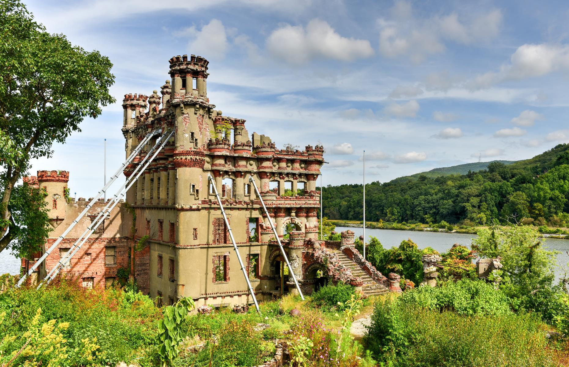 Slide 20 of 35: The ruins on deserted Pollepel Island are the symbol of one man’s lofty ambitions. This island was never home to an entire thriving community – instead it was the domain of Scottish businessman Francis Bannerman who founded a company selling military equipment, ammunition and more. In the early 1900s, Bannerman bought Pollepel Island as a safe place to store his wares and set about building the fairy-tale Scottish castle that stands crumbling on the island today.