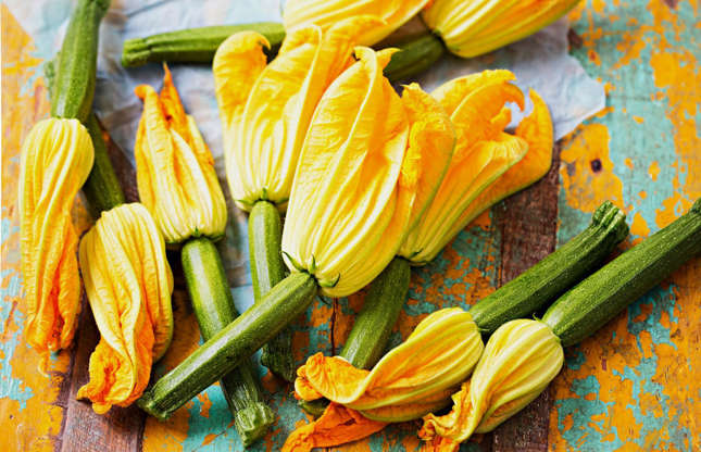 Slide 10 of 25: If you grow your own vegetables, you may recognize these bright yellow zucchini flowers which usually sprout during the summer months. But if you’ve been throwing them away, you’ve missed a trick. These delicate and slightly sweet tasting flora are delicious when stuffed with ricotta and deep-fried.