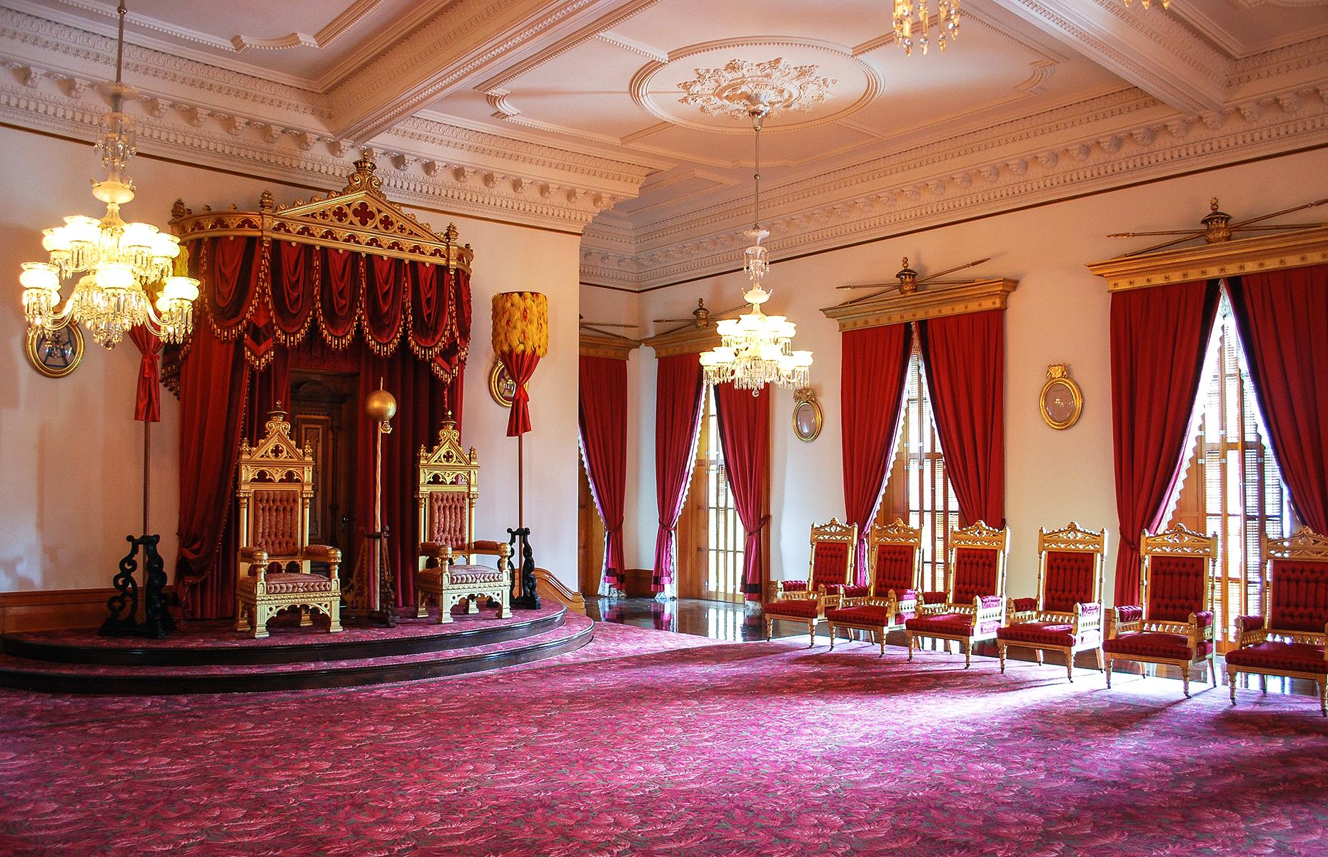 Slide 9 of 31: The interiors are equally as opulent and the Throne Room is the plushest of them all. Red velvet curtains frame vast windows, chandeliers hang heavy from the ceiling and a pair of gilded thrones sit on a raised platform. King Kalakaua and Queen Kapi‘olani were the first royals to live here, moving in as soon as their regal abode was completed. The monarchy occupied the palace until 1893 when the then-leader Queen Lili'uokalani was overthrown.