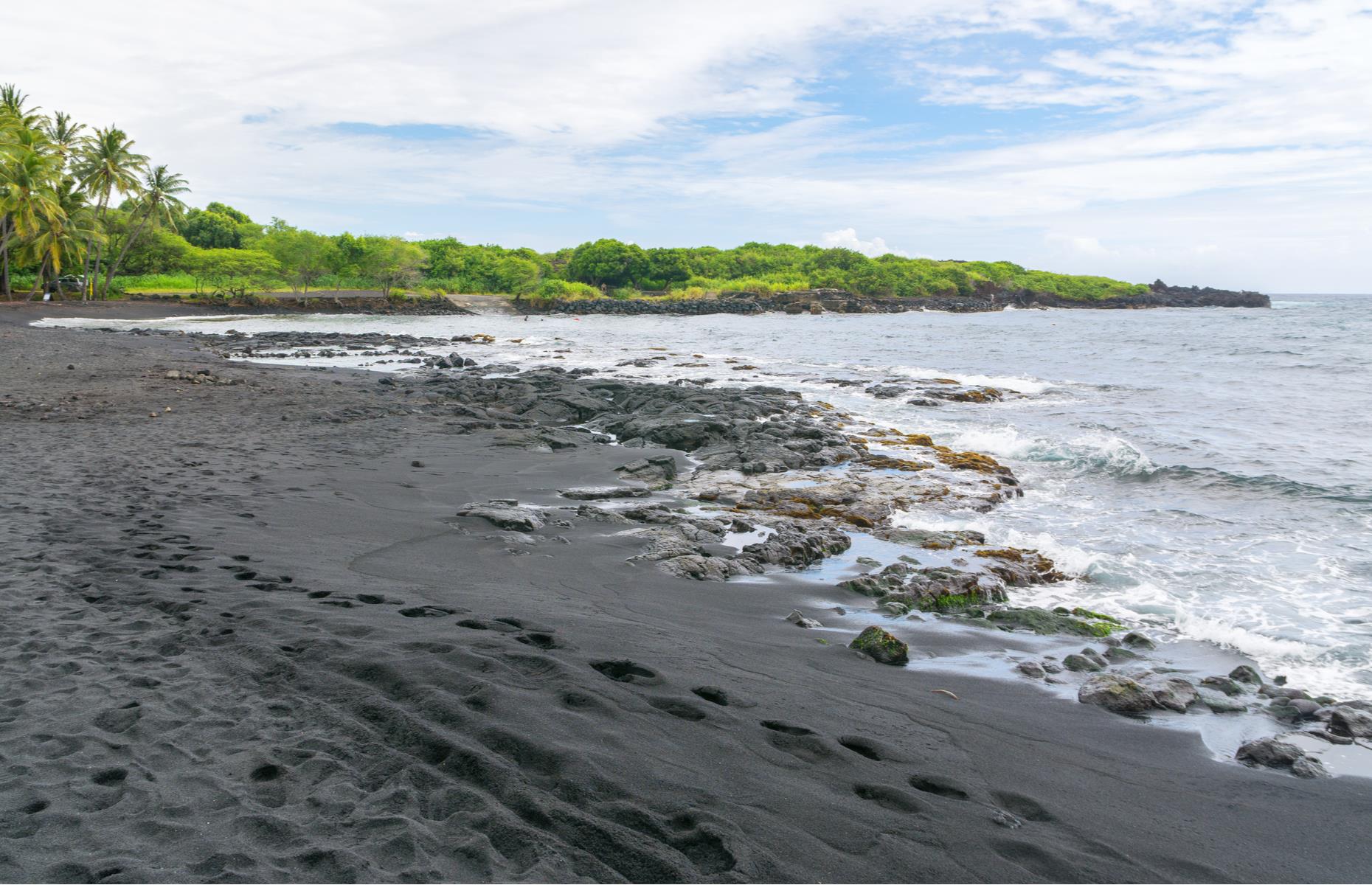 This striking black beach on Hawaii's Big Island appears as though plucked from another planet, its inky sands contrasting with bright green coconut palms and the Pacific Ocean. The fine basalt sand is formed from volcanic activity, and you may even spot Hawaiian green sea turtles (honu) sunbathing on the strand. Due to choppy waters, the beach is not the best spot for a swim, but the incredible views will keep you on the shore.