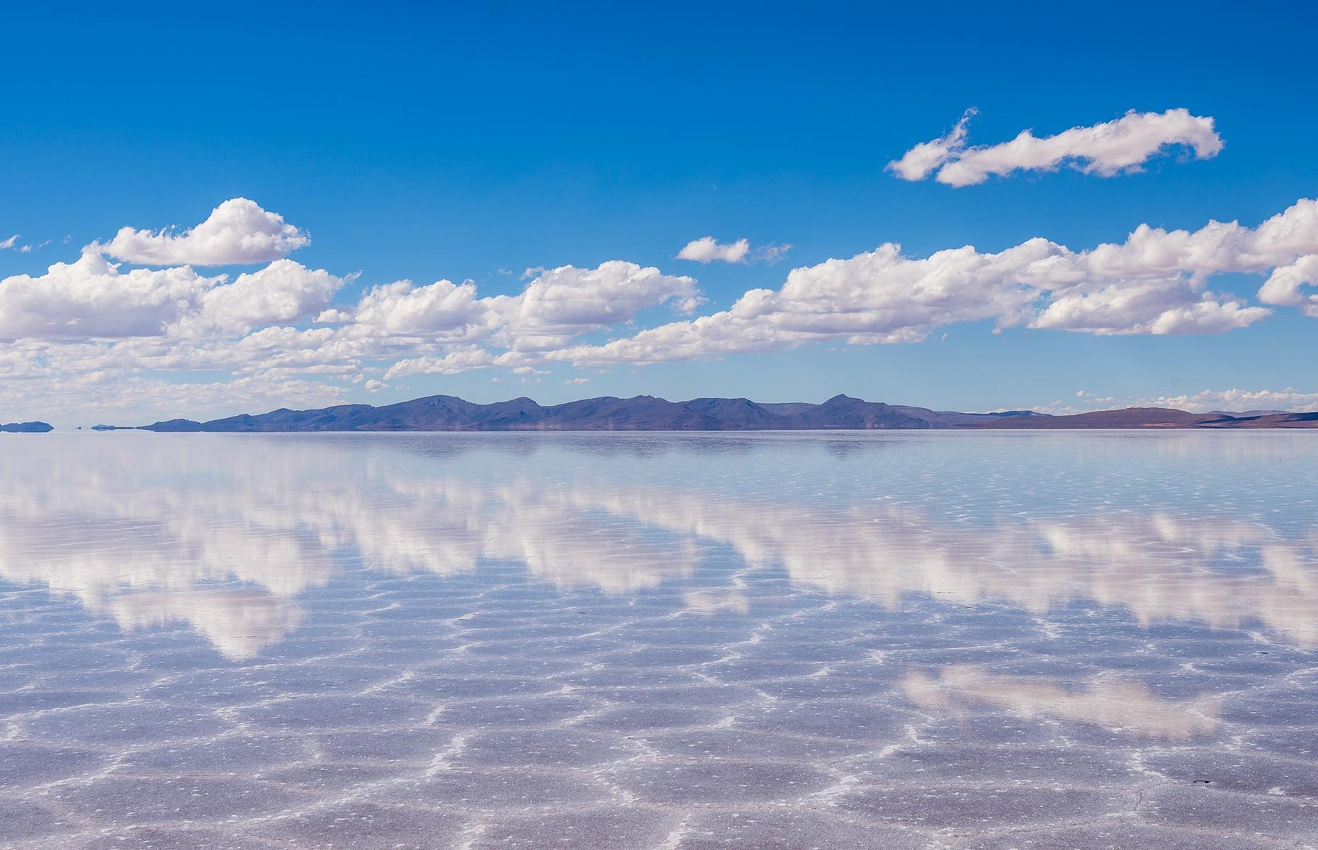 Stretching across an immense 4,086 square miles, the Salar De Uyuni is the world’s largest salt flat – and a breathtaking natural mirror. The surface becomes reflective when water floods the plane, making it look as though everything is suspended in the clouds. The dream-like spot is located in Potosí, southwest Bolivia, near the crest of the Andes.