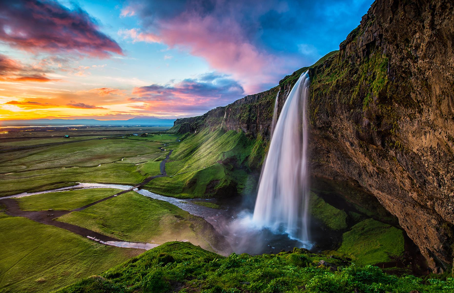 <p>Iceland seems to overflow with waterfalls, each with its own fascinating features. Seljalandsfoss, in the south, isn’t the tallest (with a drop of 200 feet/61m) but it’s one of the few waterfalls in the world that can be admired from all angles. It's beautifully contrasted by a landscape of seemingly endless green meadows, dotted with yellow and violet flowers watered by the fine spray, creating a fairy-tale like image. Here are <a href="https://www.loveexploring.com/galleries/76836/these-are-the-worlds-most-beautiful-waterfalls?page=1">the world's most beautiful waterfalls</a>.</p>