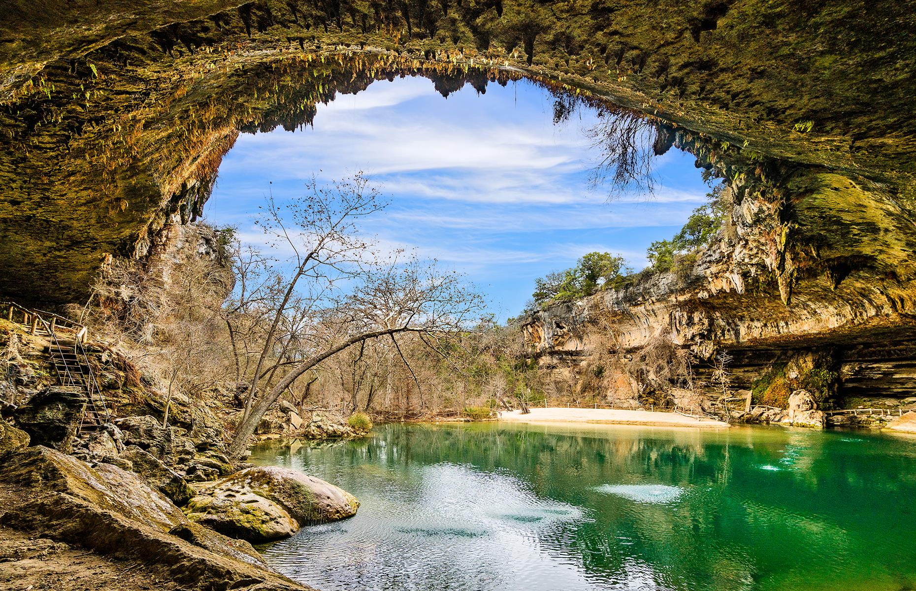 Slide 14 of 41: A beautiful spot to splash around in summer, this natural swimming hole is just 20 miles (32km) west of the Texas state capital. The bright green pool was once entirely underground until the sheltering limestone roof above it collapsed. A 50-foot (15m) waterfall feeds the pool.