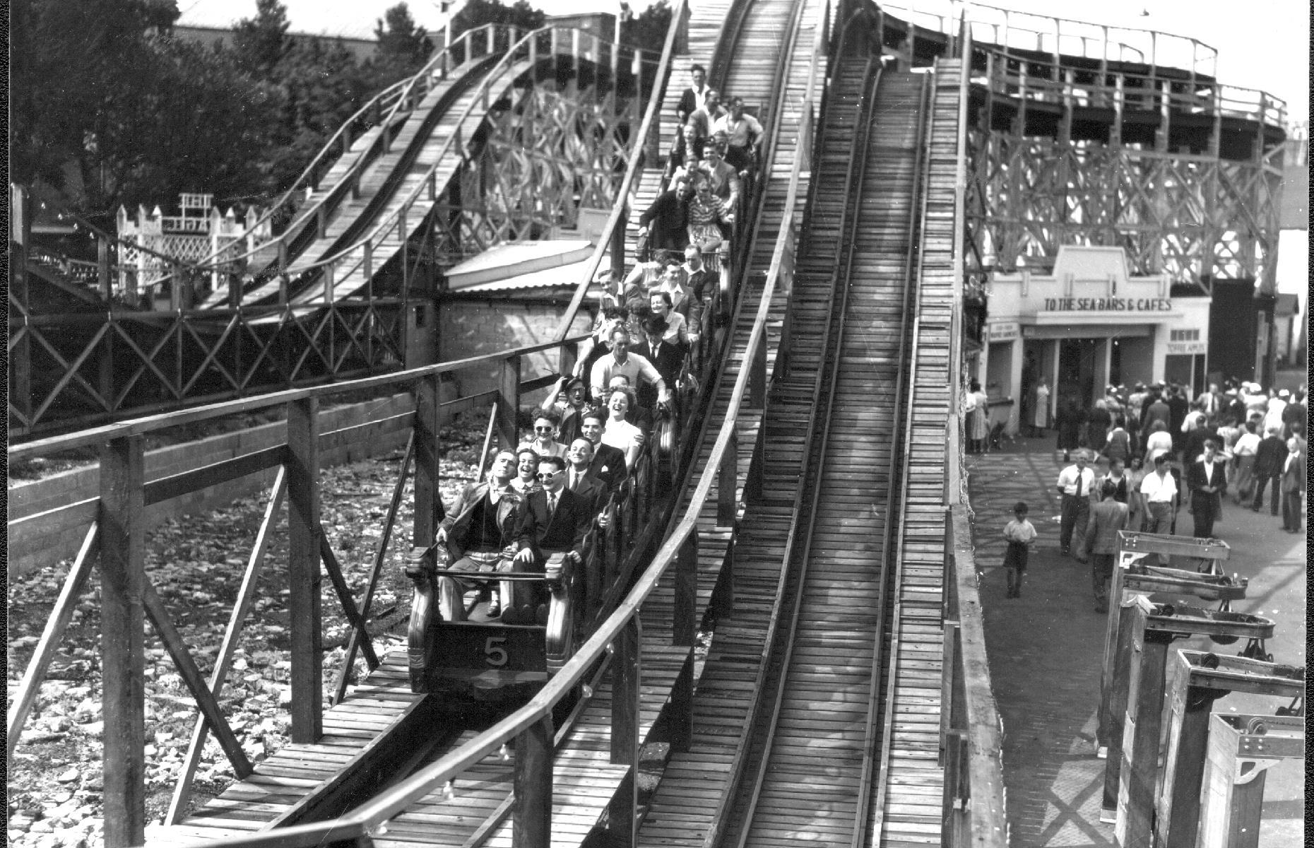 Slide 30 of 35: It was in the 1920s, however, that the park began to take its modern shape. The Scenic Railway – a wooden coaster finished in 1920 – helped seal the park's success for years to come. It was badly damaged in the fire of 2008, but has once again been restored and remains a Grade II-listed structure. It's pictured in action during the 1930s. Check out other exciting roller coasters from around the world too. 