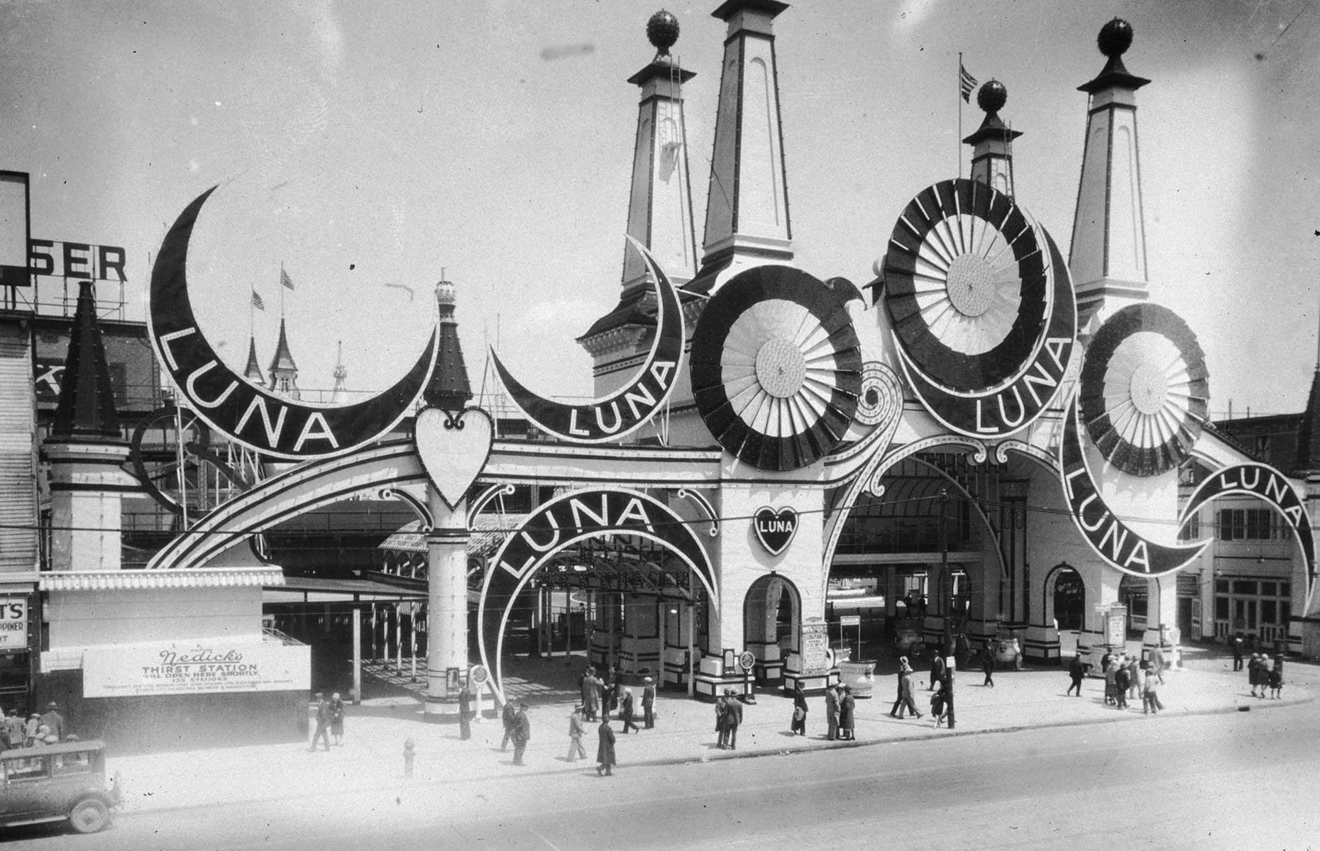 Slide 2 of 35: The fabulously kitsch rides and amusements of Brooklyn's Coney Island have certainly stood the test of time, with the very first roller coaster, the Switchback Railway, making its debut in 1884. The "island's" Luna Park, meanwhile, opened in 1903, entertaining holidaymakers for over four decades before it was ravaged by fire in 1944. Here visitors gather around the entryway, with its flags, turrets, and giant half-moons, in the early 1900s.