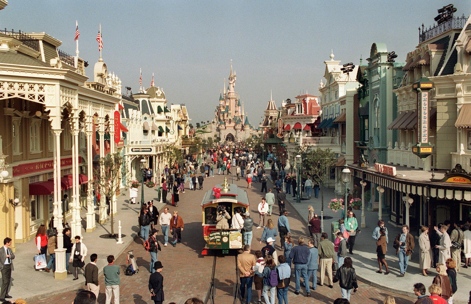 Slide 15 of 35: While it doesn't have the same long history as some of Europe's other parks, Disneyland Paris (first christened Euro Disney) is one of the best-loved of them all. When it opened in the 1990s, it was a microcosm of its American cousins, boasting a Fantasyland, Frontierland and, of course, its very own fairy-tale castle. Pictured are some of the first visitors exploring the park on the eve of its opening in 1992.