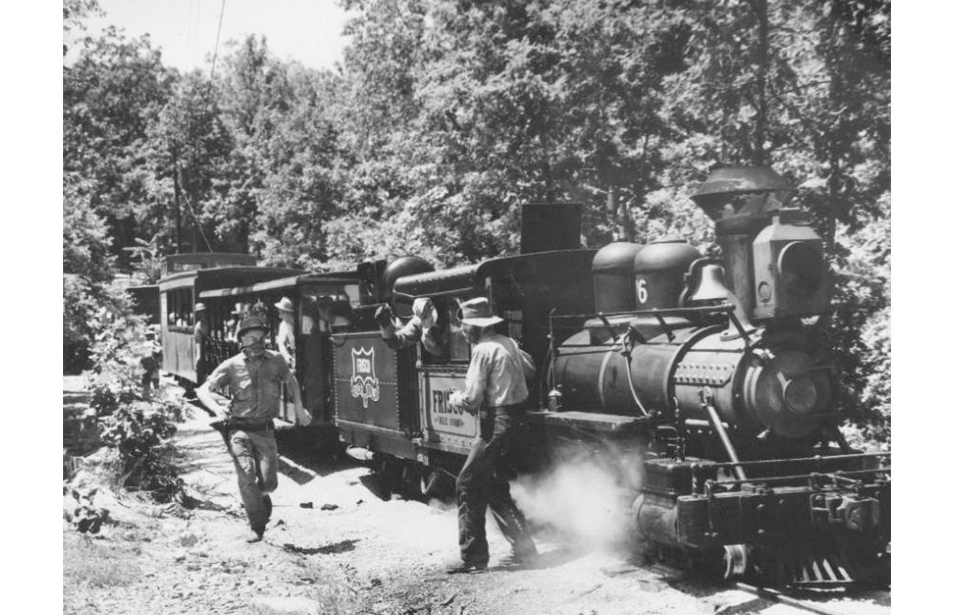 Slide 18 of 35: By the 1960s, one of Silver Dollar City's top attractions had been added: a steam train (pictured) that chugs through the leafy Ozarks countryside. But beware: along the way passengers would be (and still are) held up by train robbers that emerged from the woods ready to loot and plunder.