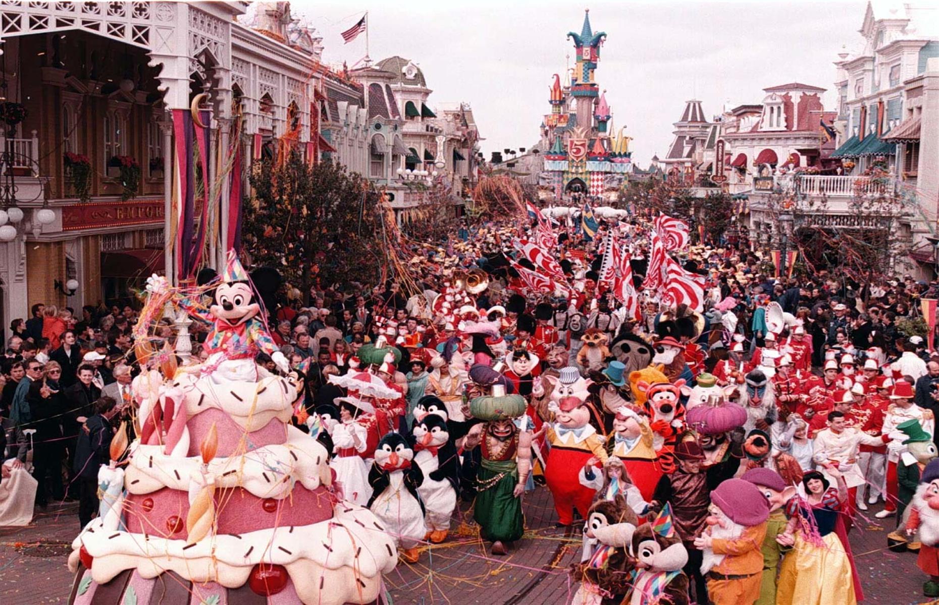 Slide 36 of 38: On 12 April 1997, Disneyland Paris (newly christened in 1994) celebrated its 5th birthday. The milestone was marked with a grand parade featuring hundreds of beloved Disney characters, from Snow White to Donald Duck. The parade saw star-of-the-show Mickey Mouse burst out from a giant birthday cake to the delight of the onlooking crowd.
