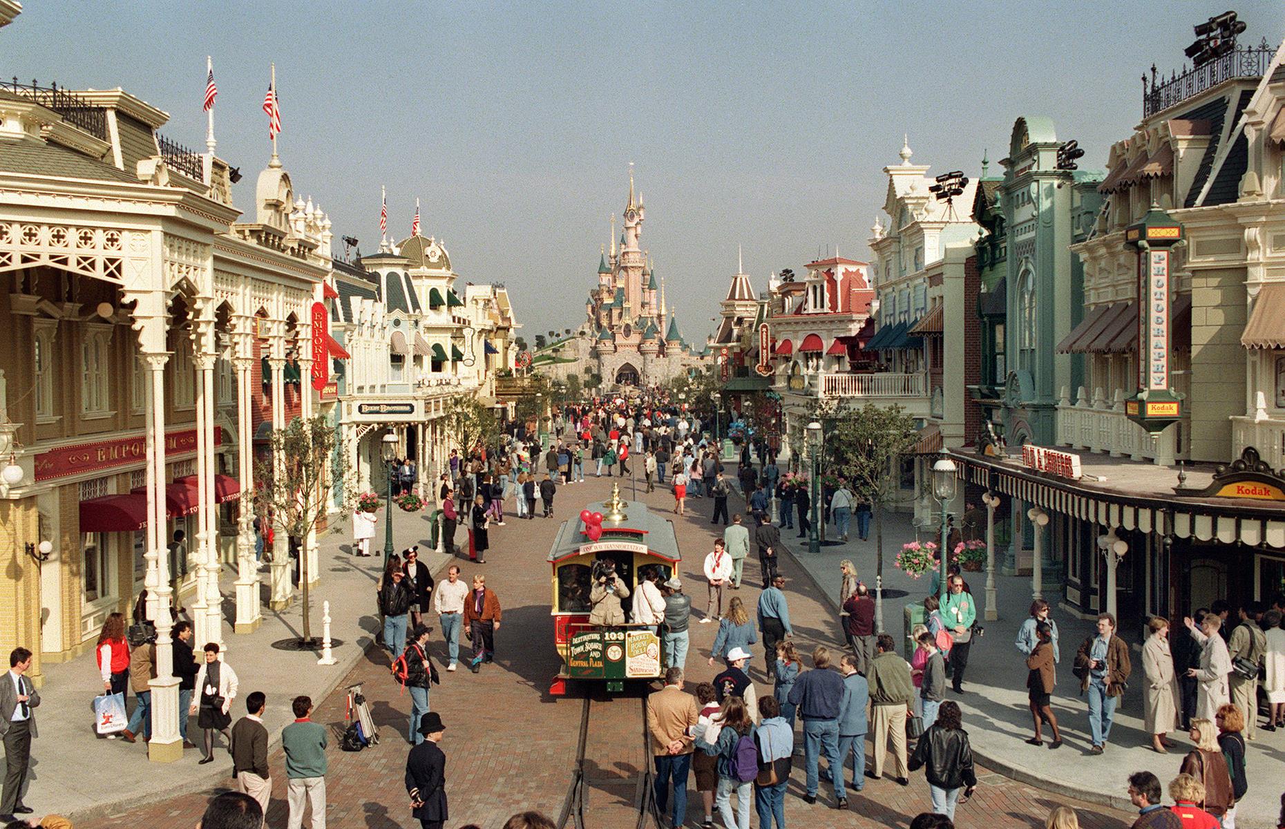 Slide 33 of 38: Located just east of the French capital, Disneyland Paris (then Euro Disney) opened to visitors on 12 April 1992. The first theme park here was Disneyland Park, which featured many familiar attractions and lands, including Fantasyland, Frontierland, Adventureland and Main Street, U.S.A. Captured in this photo are those lucky enough to enjoy a press preview, which took place on the eve of the park's opening day, on 11 April.