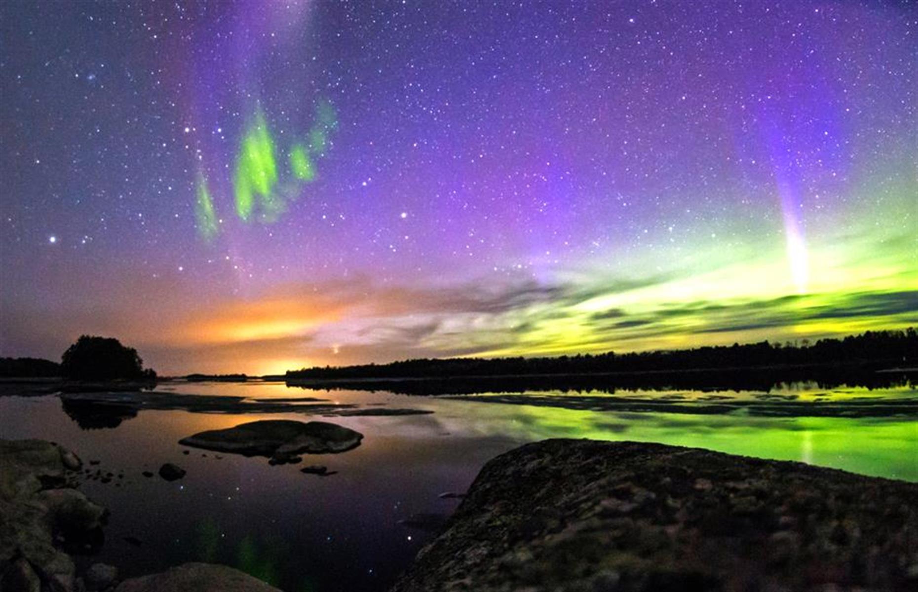 Slide 37 of 100: On clear nights, in the far northern reaches of the USA, the aurora borealis paint great sweeps of fuchsia, green and purple across the sky. The Northern Lights are caused when charged particles from the sun collide with atoms within the Earth's atmosphere, and when the conditions are right they dance above Voyageurs National Park, in remote northeastern Minnesota. Find more stunning photos of the Northern Lights here.