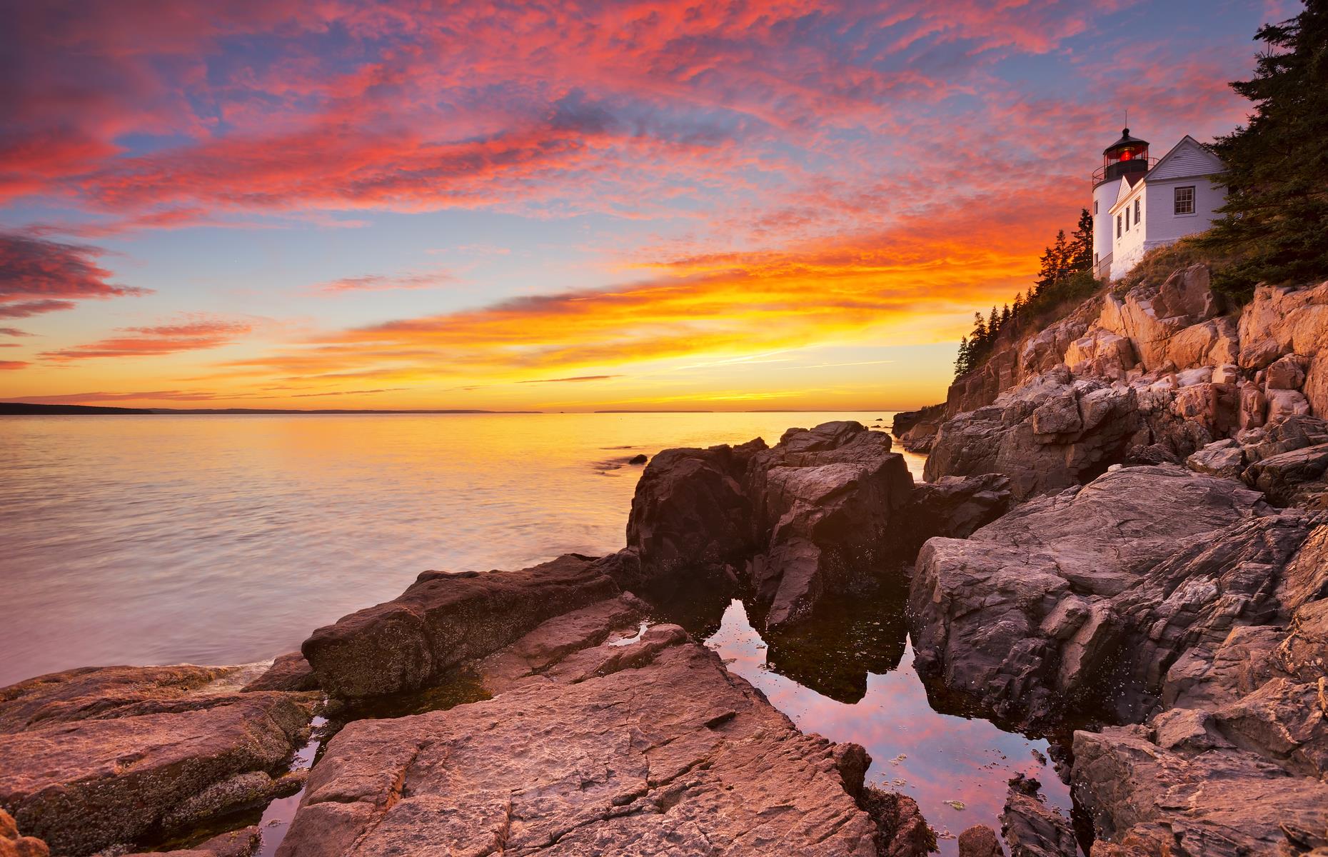 Slide 65 of 100: This national park protects a gloriously rugged stretch of the North Atlantic Coast, with jagged capes, mountains and still ponds all contained within its borders. The most famous image of the park is the Bass Harbor Head Lighthouse, perched on a cliff above the swirling ocean. The landmark dates to the 19th century and has earned itself a spot on the National Register of Historic Places.