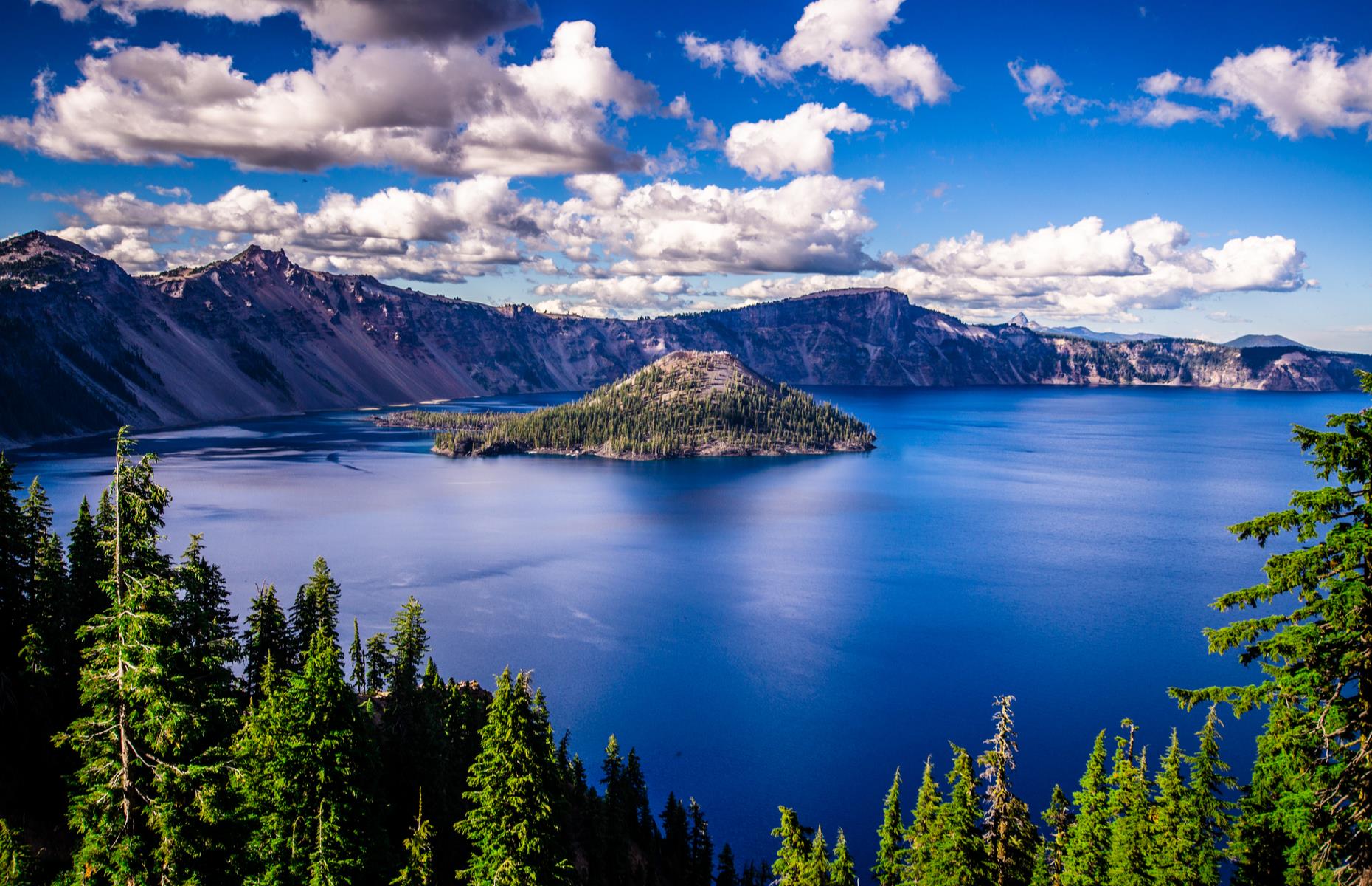Slide 88 of 100: One of the deepest lakes in the world – and the very deepest in the United States – Oregon's Crater lake was formed some 7,700 years ago, when a volcanic peak collapsed, leaving behind a vast caldera. It plunges to a depth of 1,943 feet (592m) and its vivid sapphire waters are ringed by mountains and old-growth forest.