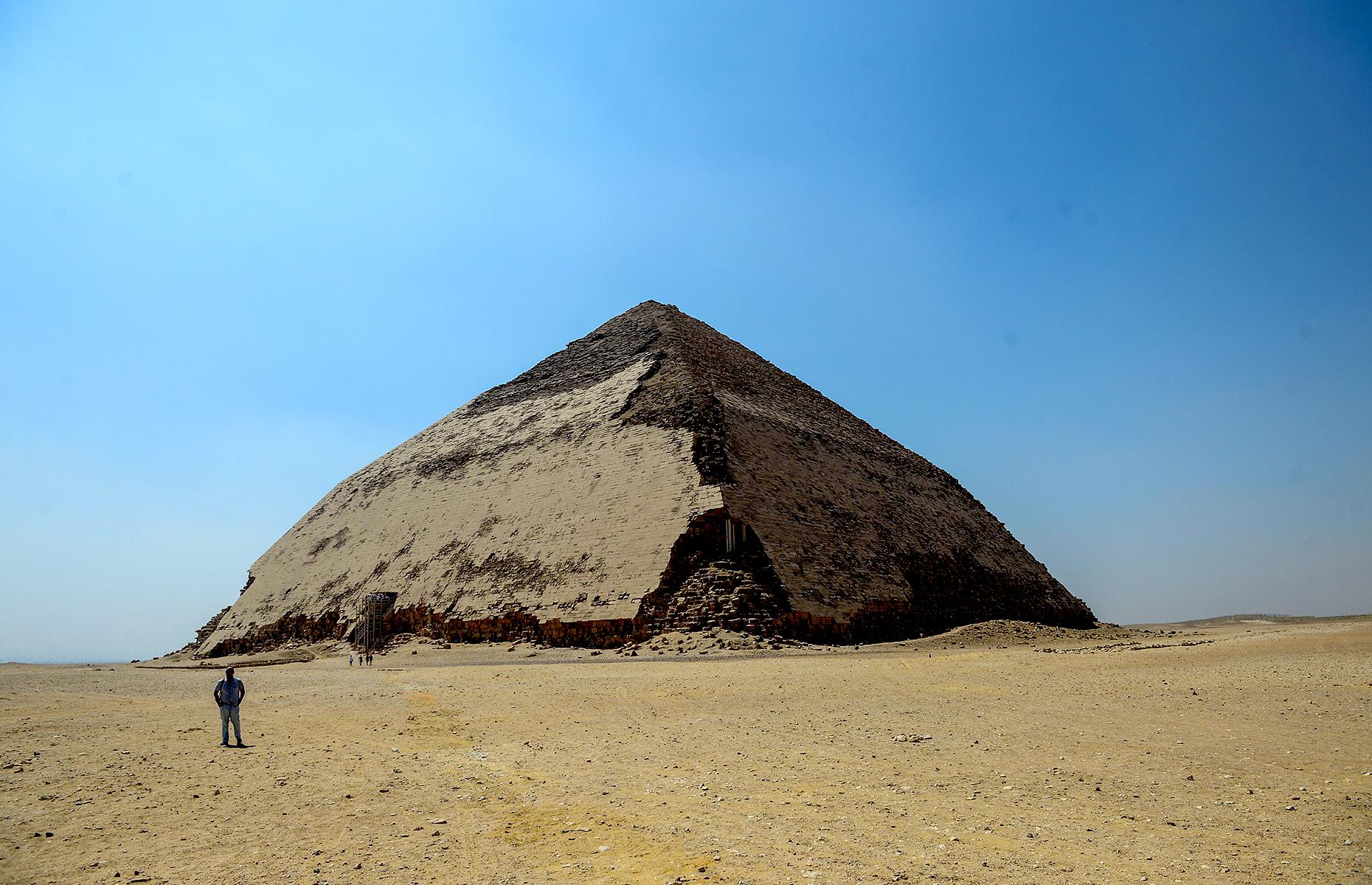 Slide 4 of 50: It might not be the most famous of Egypt's pyramids, but this striking structure in Dahshur still has secrets aplenty. Reopened to the public in 2019 for the first time since the 1960s, the Bent Pyramid (so named for its curious shape) sits around 25 miles (40km) south of capital Cairo. It's thought to be around 4,600 years old, dating back to 2,600 BC, when it was built for the pharaoh Sneferu. But despite its many millennia, its riches are only just being discovered.