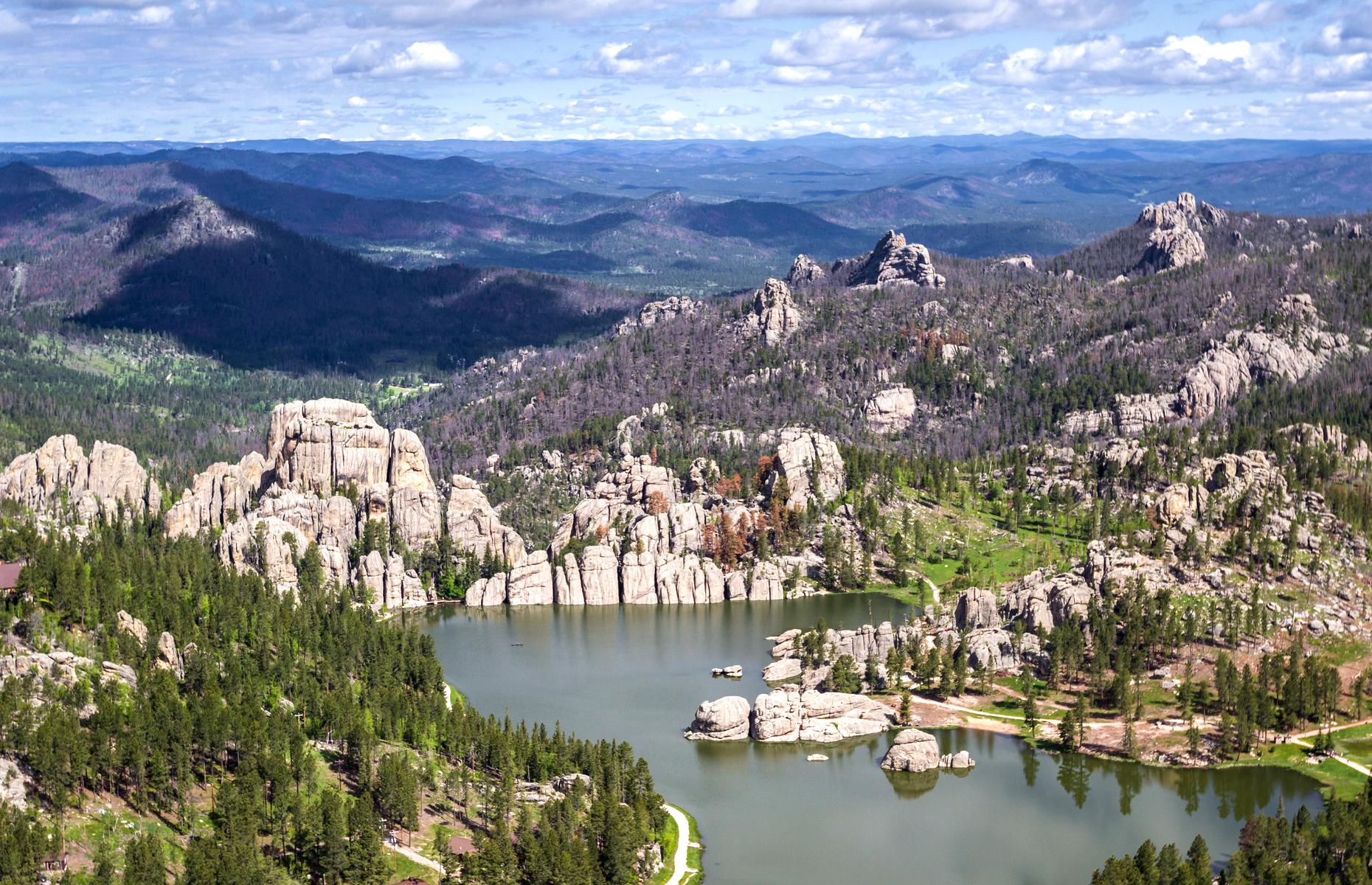 Slide 36 of 45: From twisting rock to glossy lakes, you needn't look far to find an impressive view in South Dakota. One such vista is Sylvan Lake, tucked away in the Black Hills' Custer State Park and captured from the sky in this image. The lake remains one of the most popular spots in the 71-acre preserve, drawing swimmers, kayakers and photographers alike. This is the most stunning state park in every state.