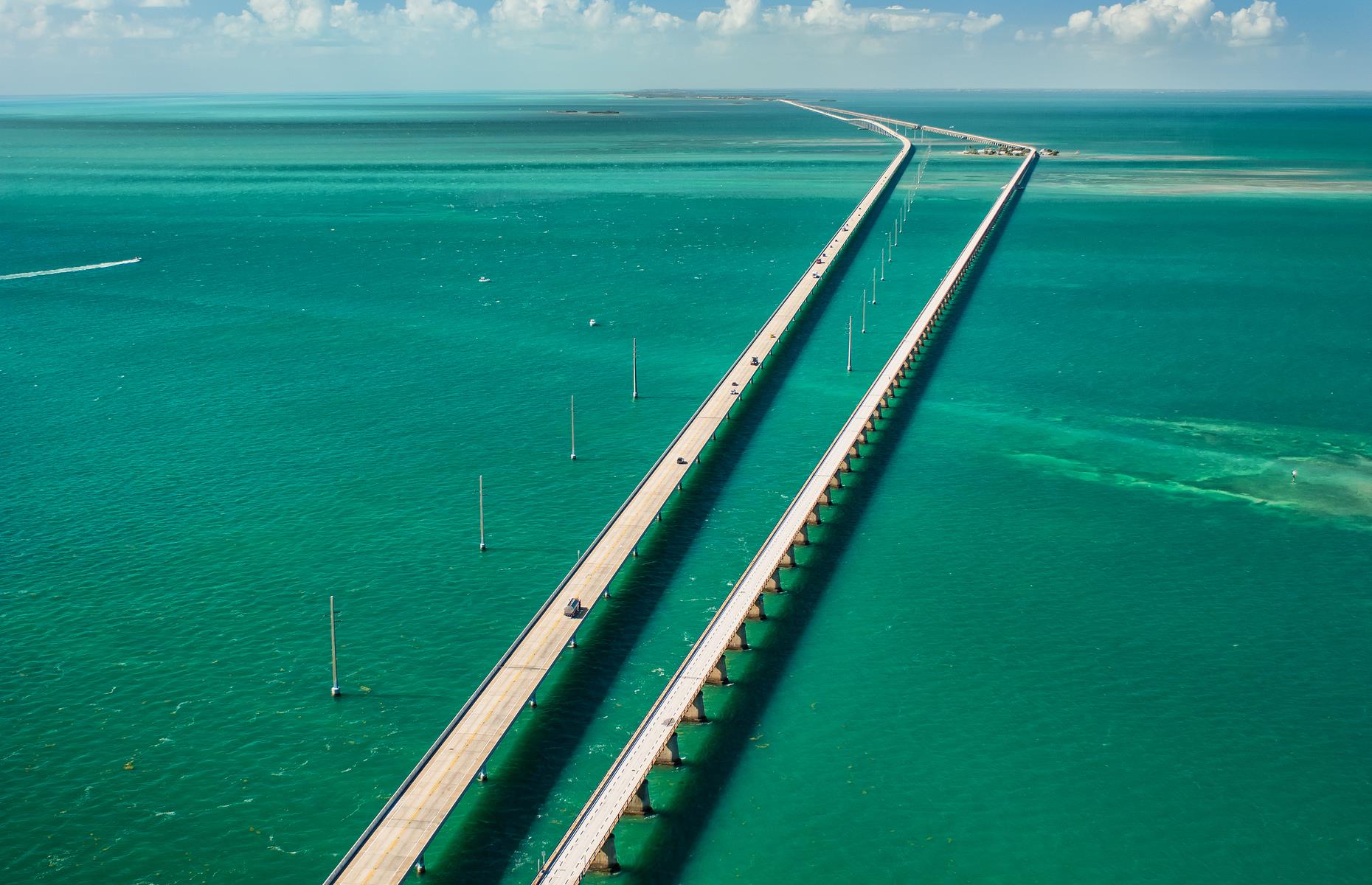 Slide 15 of 45: The Seven Mile Bridge strings together Knights Key in the Middle Keys area and Little Duck Key in the Lower Keys. The bridge soars over the water, its gray expanse contrasting with the perfect blue-green sea on either side. While the open road grants gorgeous ocean views, the structure itself looks most impressive from above. 