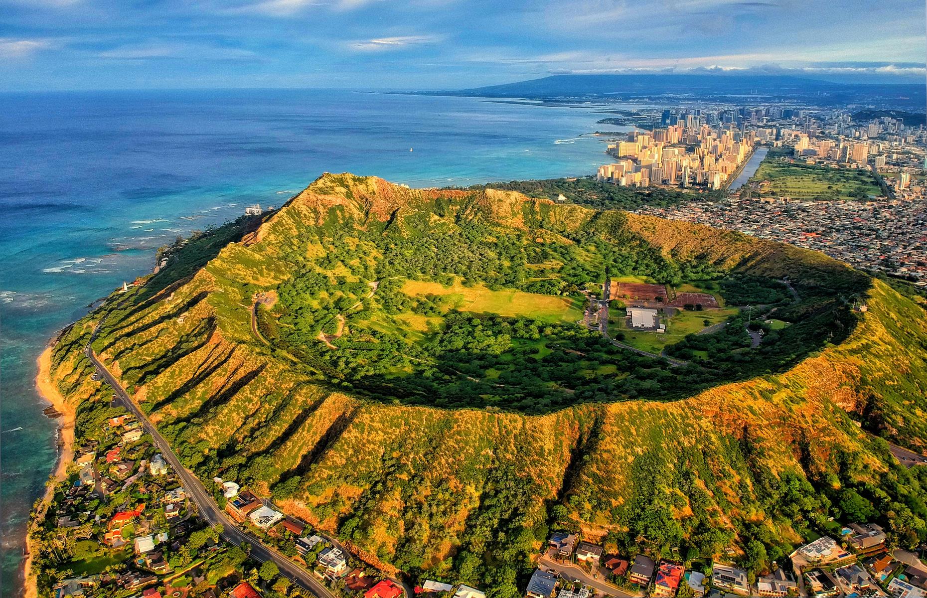 Slide 28 of 45: Diamond Head on Hawaii's island of Oahu is a 200,000-year-old volcanic crater whose outer slopes can be ascended via a rugged hiking trail. From the top of the trail, there are impressive views of Honolulu, Hawaii's capital, as well as vistas of the Pacific Ocean. 