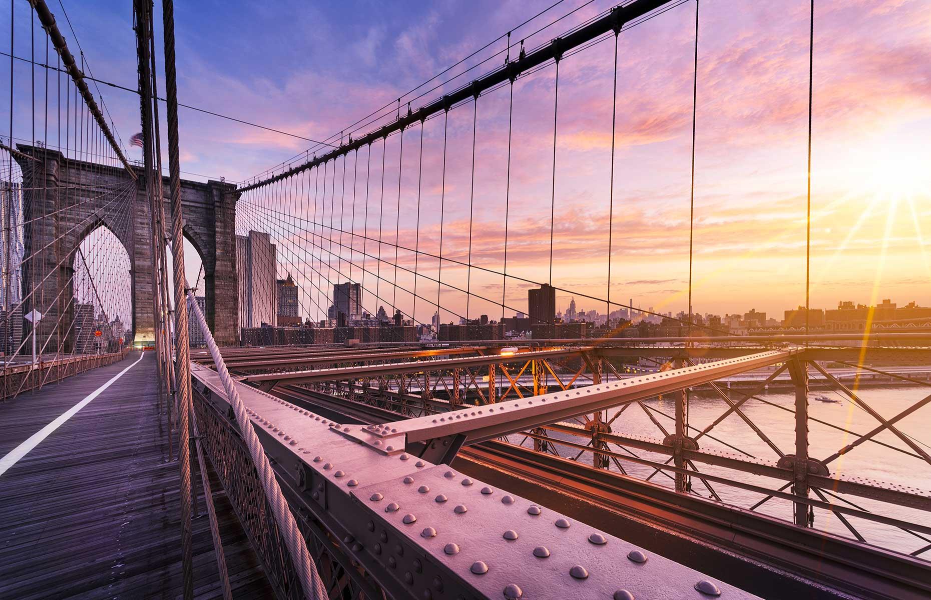Slide 7 of 29: A magnificent sunrise doesn’t always mean being in the middle of nowhere. Beat the usual crowds of New York City and set your alarm to watch the sunrise over Brooklyn Bridge. Watch the spectacle from the bridge, or take a walk towards the Manhattan skyline and watch the Big Apple aglow. Explore New York with our brilliant city guide.