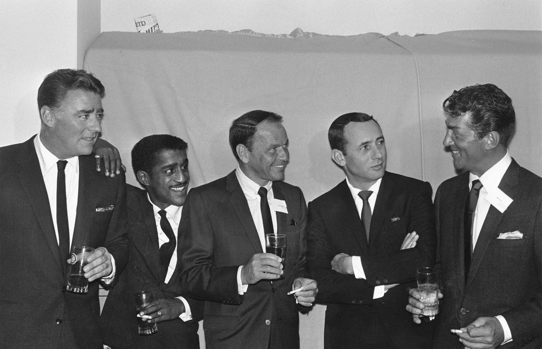 Slide 19 of 34: The Rat Pack (pictured here) are often praised for their desegregation efforts in Las Vegas. When Sammy Davis Jr headlined at the Frontier Casino, he wasn't allowed to stay in the city's hotels, like all Black performers at the time. He wasn't provided with a dressing room and was required to wait outside by the pool between acts. With the Rat Pack's support, Davis Jr later refused to work in any establishment with racial segregation until full desegregation in 1960. When The Moulin Rouge opened in May 1955, it became the first integrated casino in Las Vegas.