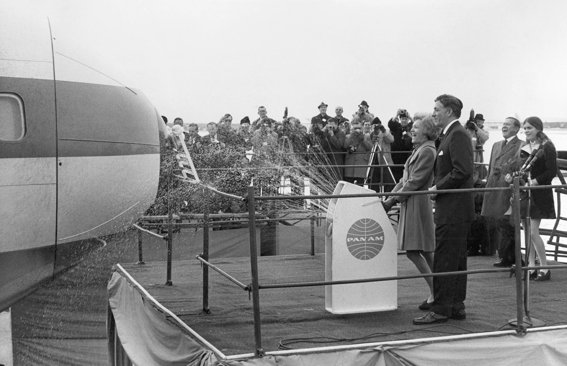 Another major leap for commercial air travel in this decade came with the introduction of the Boeing 747, a wide-bodied jet aircraft able to carry many more passengers than its predecessors. Here, the American First Lady Patricia Nixon sprays Champagne onto the aircraft ahead of its maiden commercial flight from New York to London in service with Pan Am in January 1970.