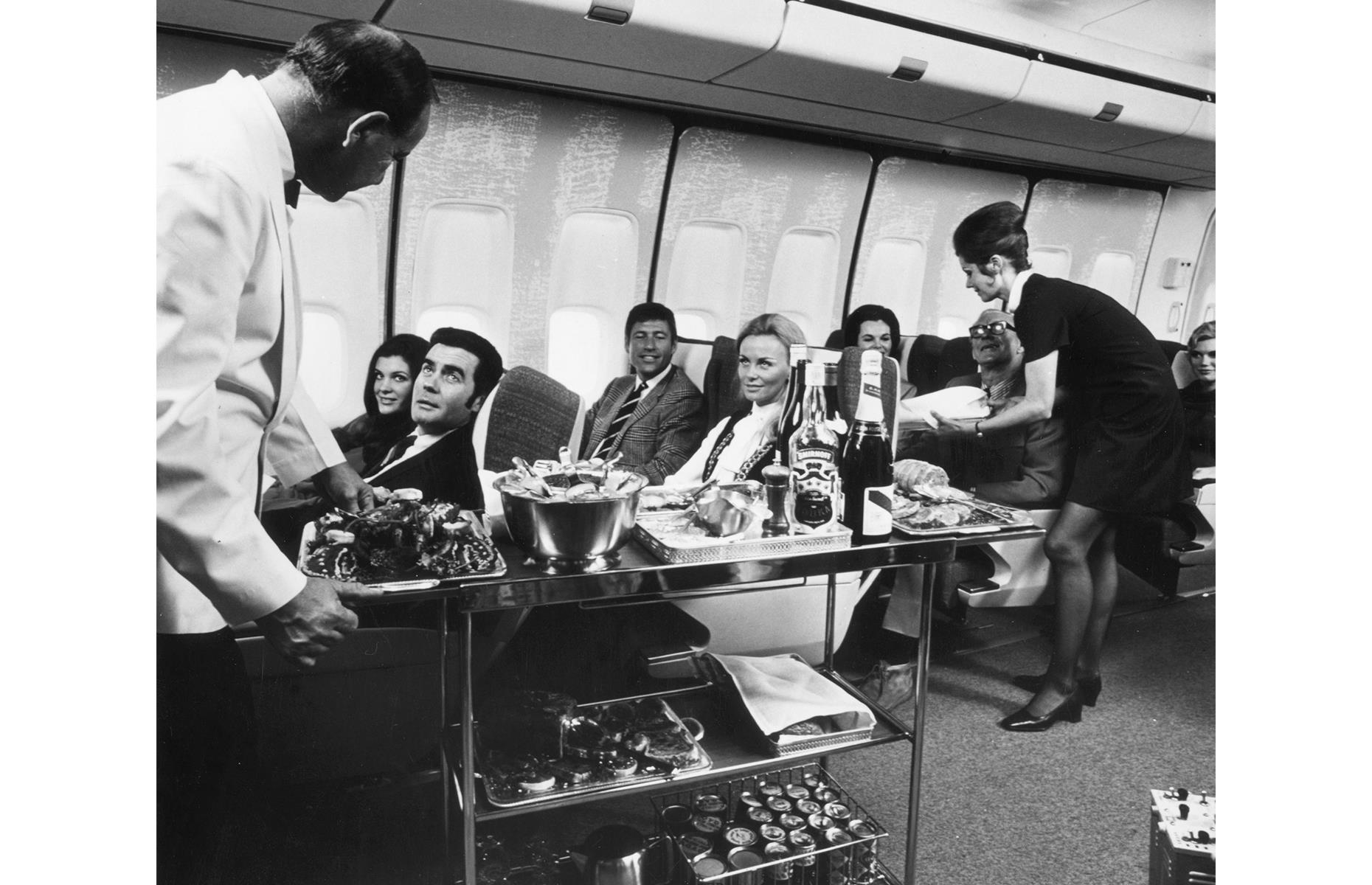 The long and lavish onboard lunches that characterized the "golden age of travel" weren't lost in the first-class cabin in the 1970s either. In this shot, taken on 22 January 1970, flight attendants carve ham seat-side, their trolley weighed down with bread and fine wine and spirits.