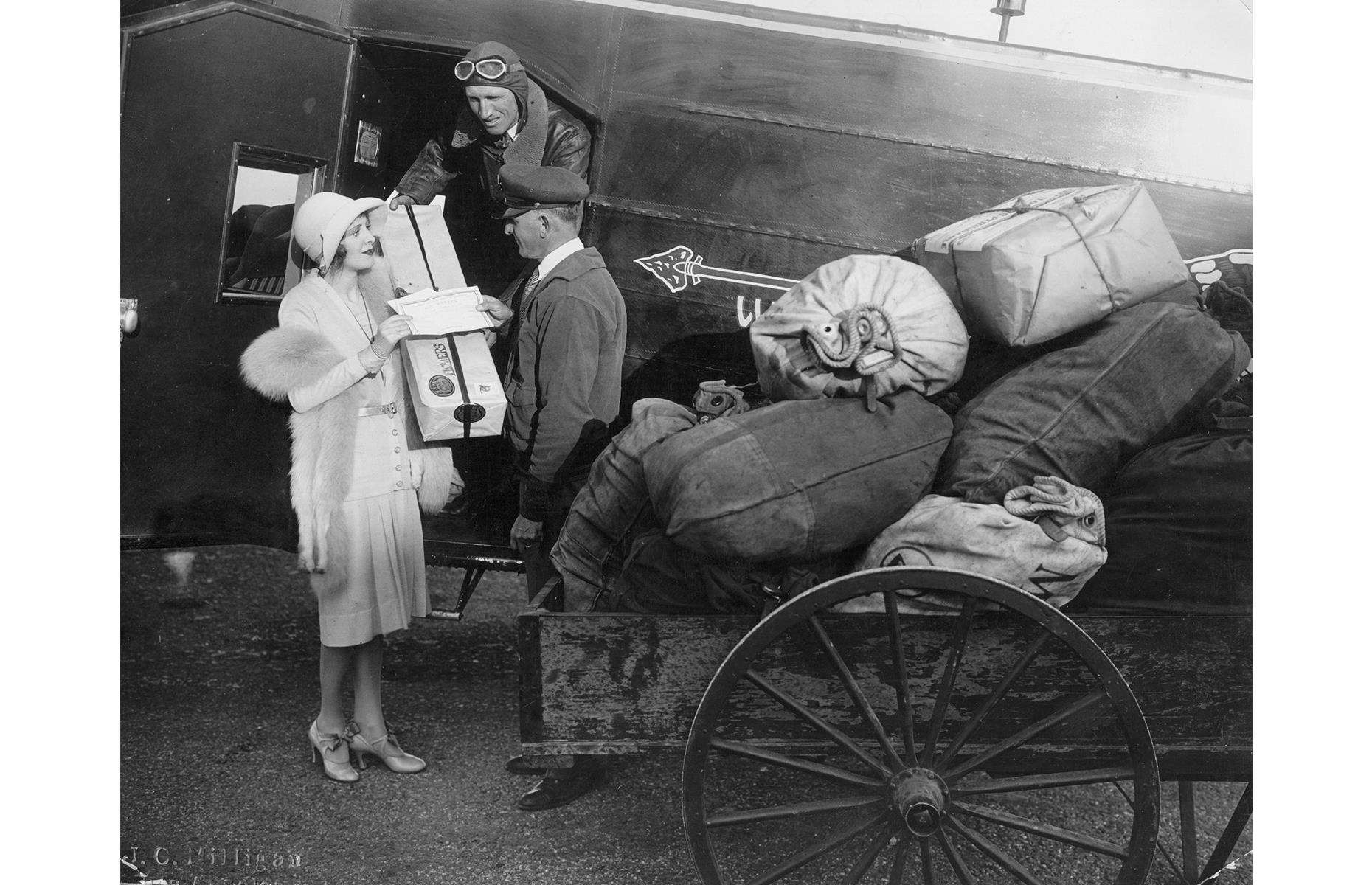<p>The early 1930s continued in a similar fashion to the 1920s, with airlines offering airmail delivery services and also carrying passengers. Flying was still extremely expensive and fairly uncomfortable but, <a href="https://airandspace.si.edu/exhibitions/america-by-air/online/innovation/innovation15.cfm">according to the Smithsonian National Air and Space Museum</a>, the number of airline passengers grew from 6,000 in 1930 to 450,000 in 1934. Here, a woman passes on her mail to the crew of a Fokker F.10 monoplane operated by Western Air Express.</p>
