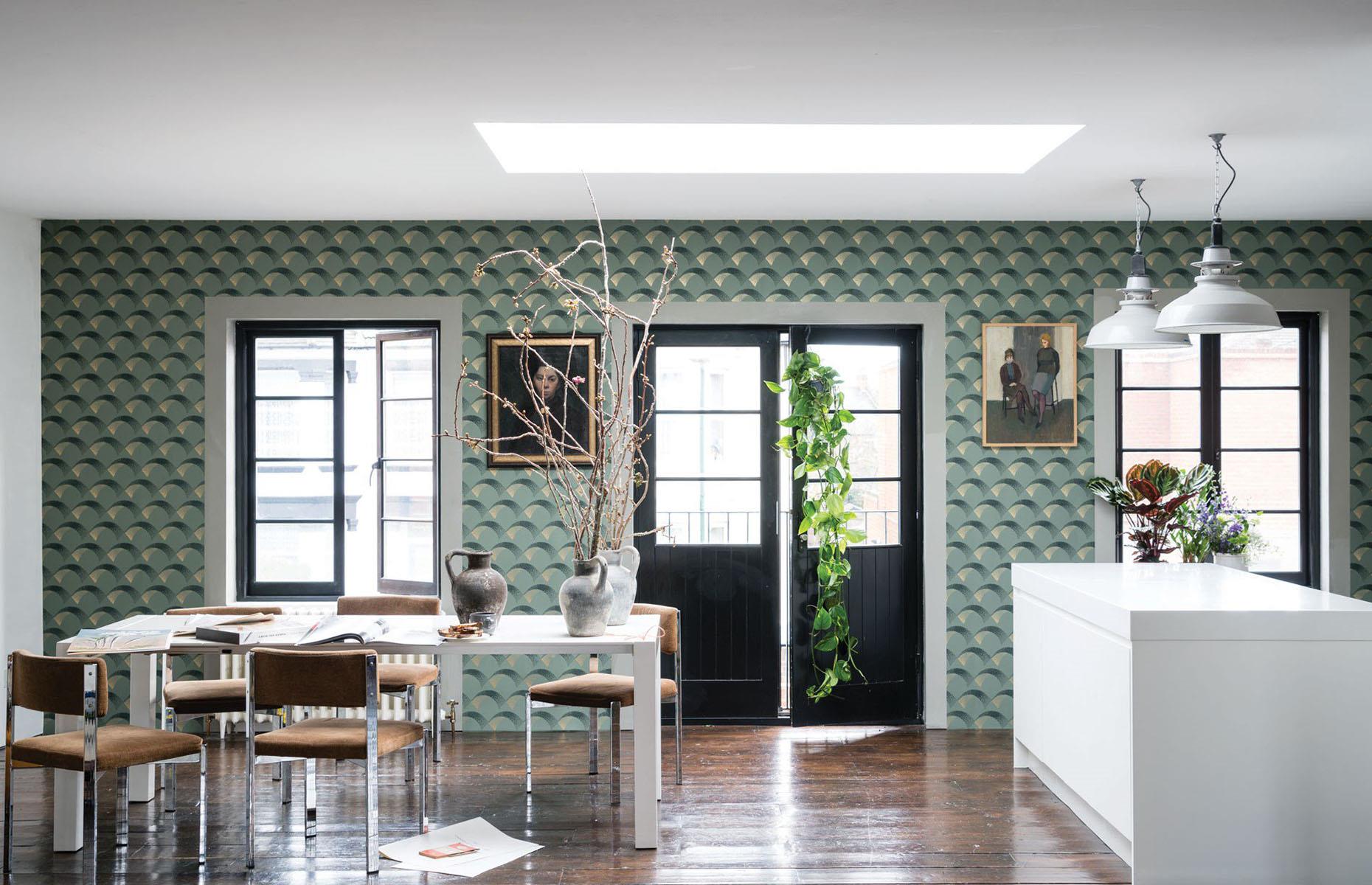 <p>If your multiuse space feels unharmonious and disjointed, a bold design choice can be the unifying element you need. This Art Deco-inspired Farrow & Ball wallpaper helps tie together the kitchen and dining space with ease, creating a colorful feature wall that balances out the crisp white table and island.</p>