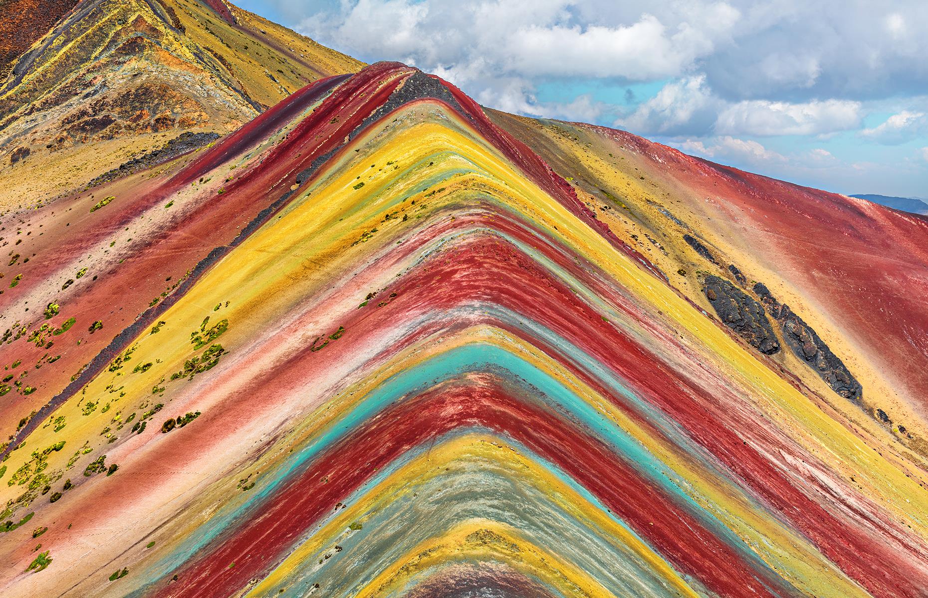 Slide 41 of 43: This multicolored mountain in the Peruvian Andes is not man-made despite what its perfectly symmetrical layers might make you think. The colorful bands, ranging from pink and red to yellow and green, are the result of sedimentary layers forming from mineral deposits over the years.