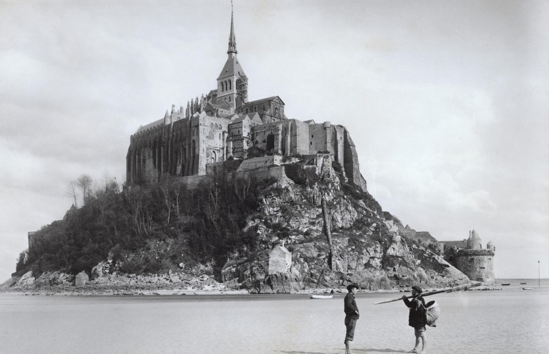 A picturesque monastery sitting atop a small island off the coast of Normandy, Mont Saint-Michel is one of the most visited landmarks in France. Built in the 8th century, it was a popular attraction from the get-go, drawing in a vast number of pilgrims from across Europe who were desperate to see the magnificent structure. Pictured here in circa 1900, two fishermen can be seen on the tidal flats in the foreground.