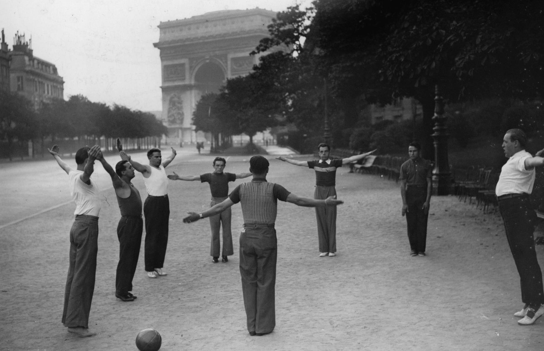 <p>This striking photograph from the 1920s shows a group of men taking part in an outdoor exercise class next to the Arc de Triomphe – an activity you might have difficulty with during peak season nowadays! The iconic arch was commissioned by Napoleon I in 1806, intended to celebrate the victories of the French army in the Battle of Austerlitz (1805) and it took 30 years to build. </p>