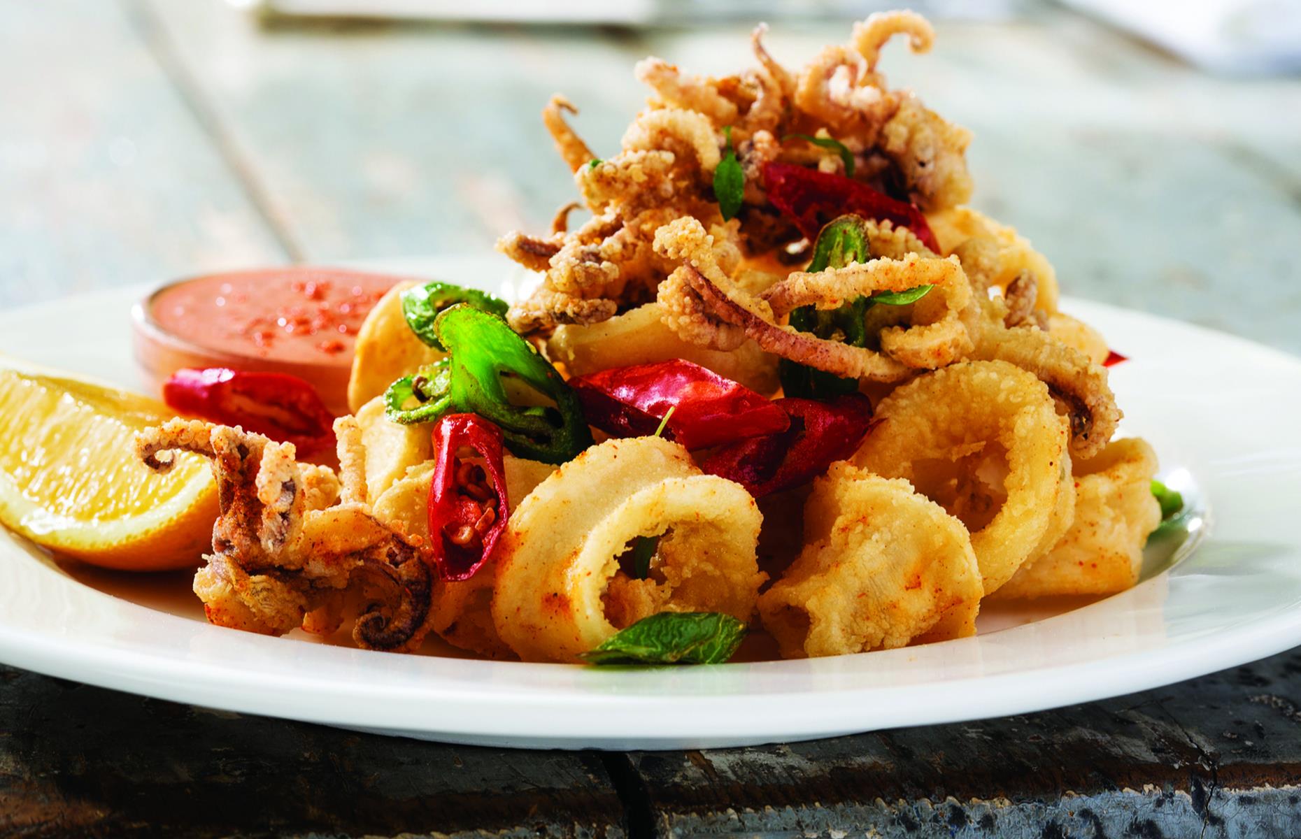 <p>It’s not just any calamari, though. The official dish is <a href="https://www.towndock.com/recipes/recipe-rhode-island-style-calamari">Rhode Island–style calamari</a>, where tubes and tentacles are dusted in flour laced with pepper and garlic before being pan-fried and tossed with hot cherry peppers and more garlic. Pickle brine is sometimes added for extra tang and the tender pieces are often tipped out onto a bed of crisp lettuce.</p>  <p><strong><a href="https://www.lovefood.com/galleries/98861/americas-oldest-surviving-food-brands?page=1">Now take a look at America's oldest surviving food brands</a></strong></p>