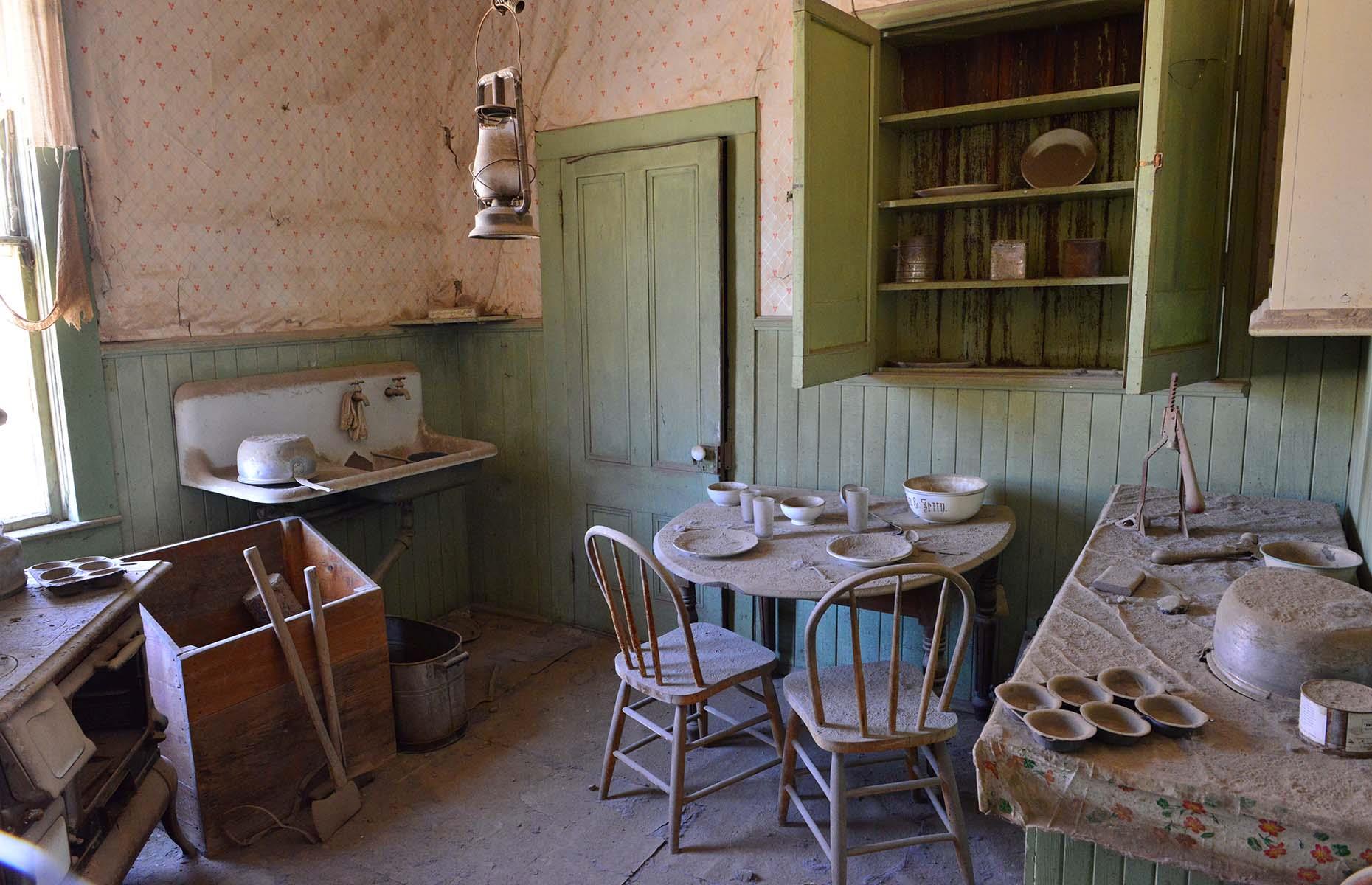 Slide 21 of 46: Over time, the mines became too expensive to run and in 1932 a huge fire burned 90% of the town to the ground. The 200 buildings that remain are now preserved as ruins – tables are still laid with crockery and in the school books lie scattered on desks.