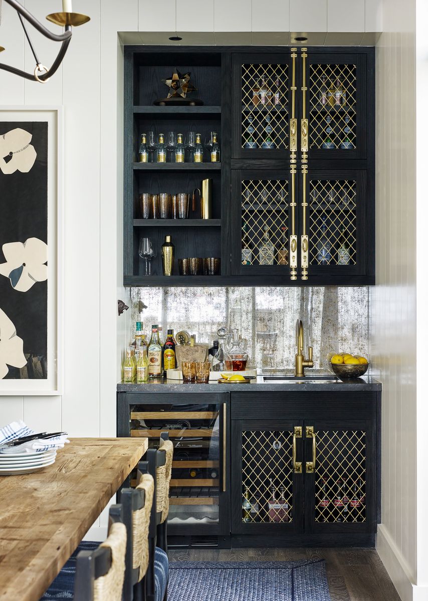 <p>Bar cabinetry faced in brass diamond-patterned grilles and espagnolette references agrarian metalwork. Wine refrigerator, <a href="https://www.subzero-wolf.com/">Sub-Zero</a></p>