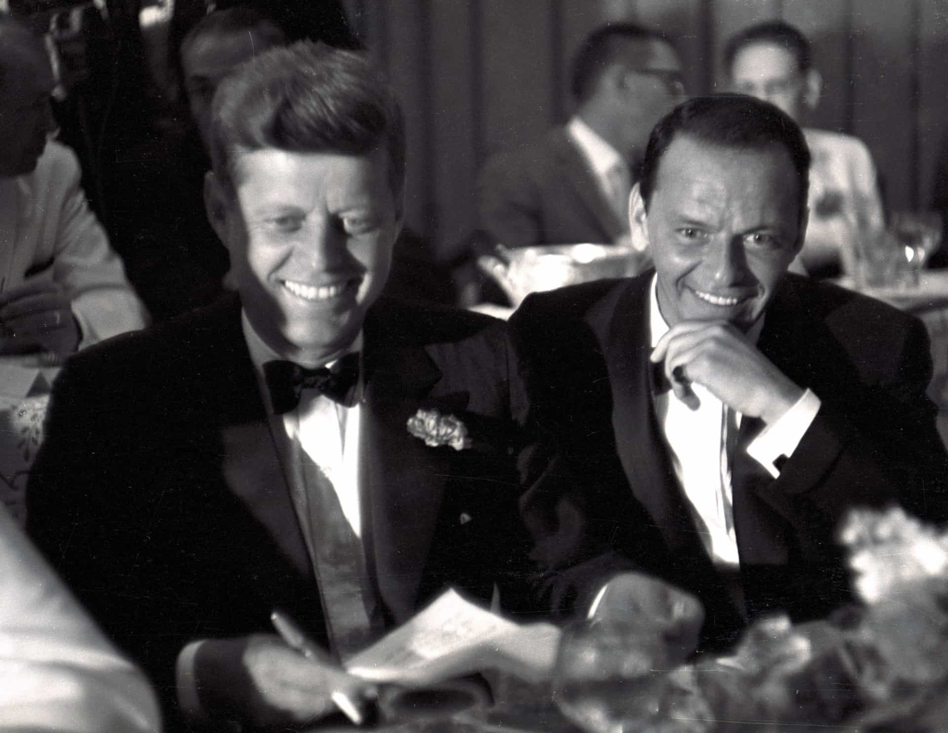 Senator John F. Kennedy und Frank Sinatra lachen am 10. Juli zusammen beim Dinner des Demokratischen Komitees im Beverly Hilton Hotel in Los Angeles.