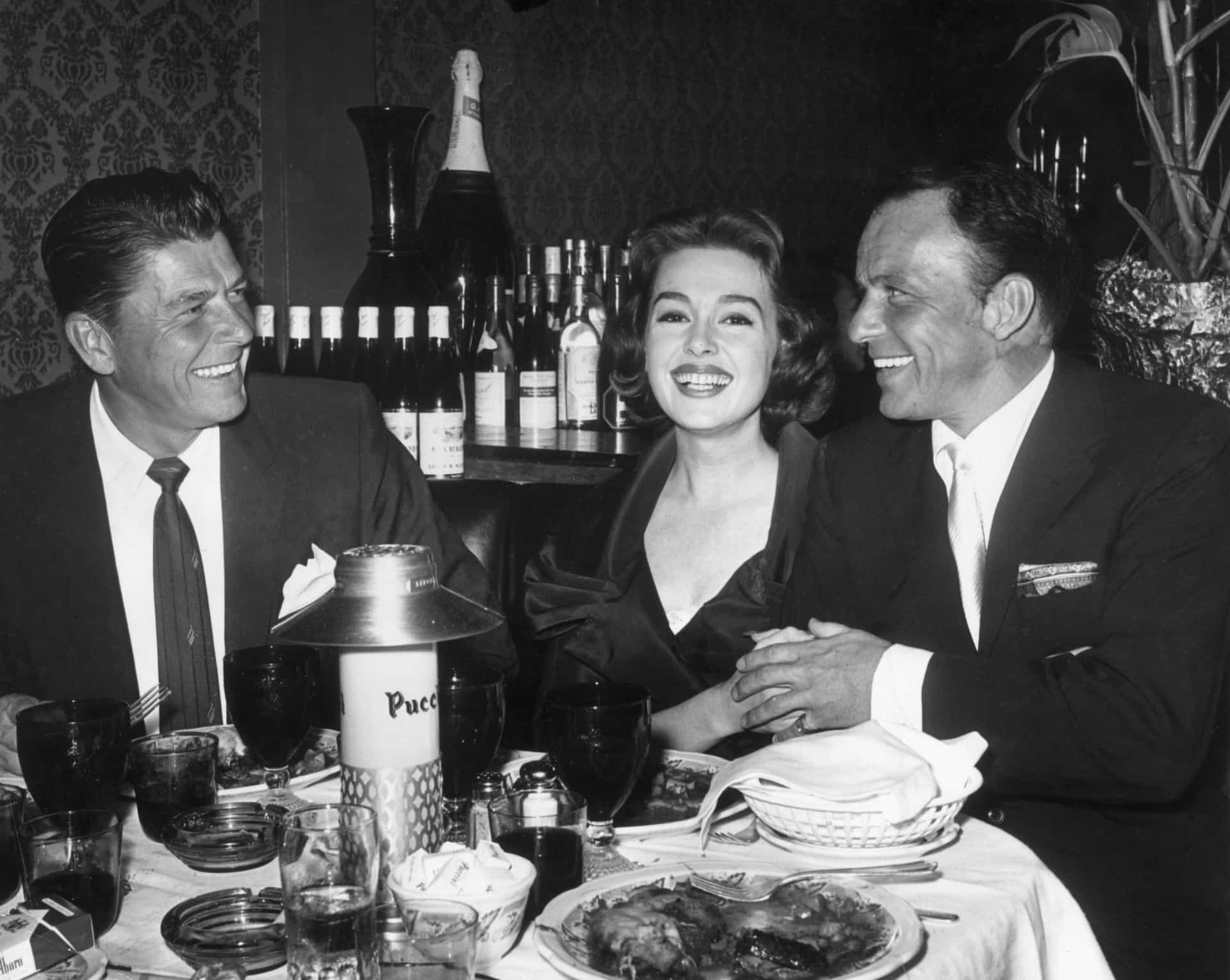 Die Schauspieler Ronald Reagan, Barbara Rush und Frank Sinatra speisen nach der Premiere von Sinatras Film "Ein Loch im Kopf" im Puccini's.