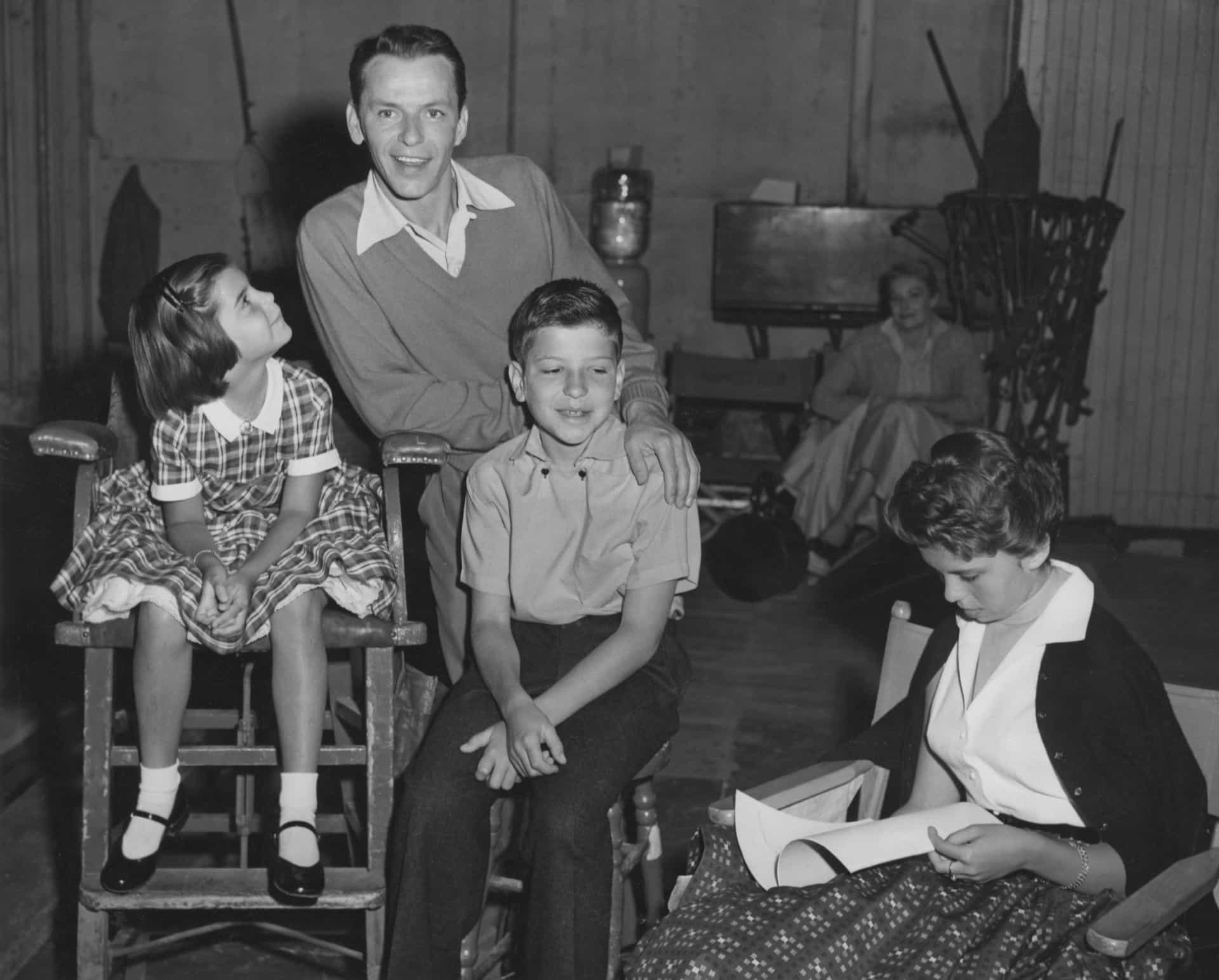 Frank sitzt mit seinen drei Kindern aus seiner Ehe mit Nancy Barbato am Set von "The Tender Trap" (1955): Christina (links), Frank Jr. (Mitte) und Nancy (rechts).