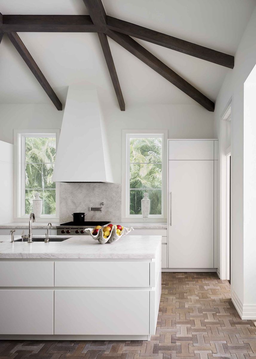 <p>Dark stained beams and interlocking white oak floor tile from <a href="https://jamiebeckwithcollection.com/">Jamie Beckwith</a> add just a hint of rustic warmth to this serene white kitchen in a <a href="https://www.veranda.com/home-decorators/a32166023/celerie-kemble-naples-florida-house-tour/">Naples, Florida, retreat</a> designed by <a href="http://www.kembleinteriors.com/">Celerie Kemble</a>.</p>