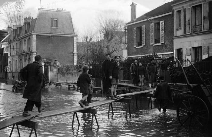 23 of 64 Photo in Gallery: While it wasn’t quite the deluge of the historic 1910 flood, a swollen River Seine burst its banks once again in 1944, flooding Paris’ embankments and piers. The newly liberated Parisians went about their business by boat and along precarious-looking wooden walkways, set up above the rising water.