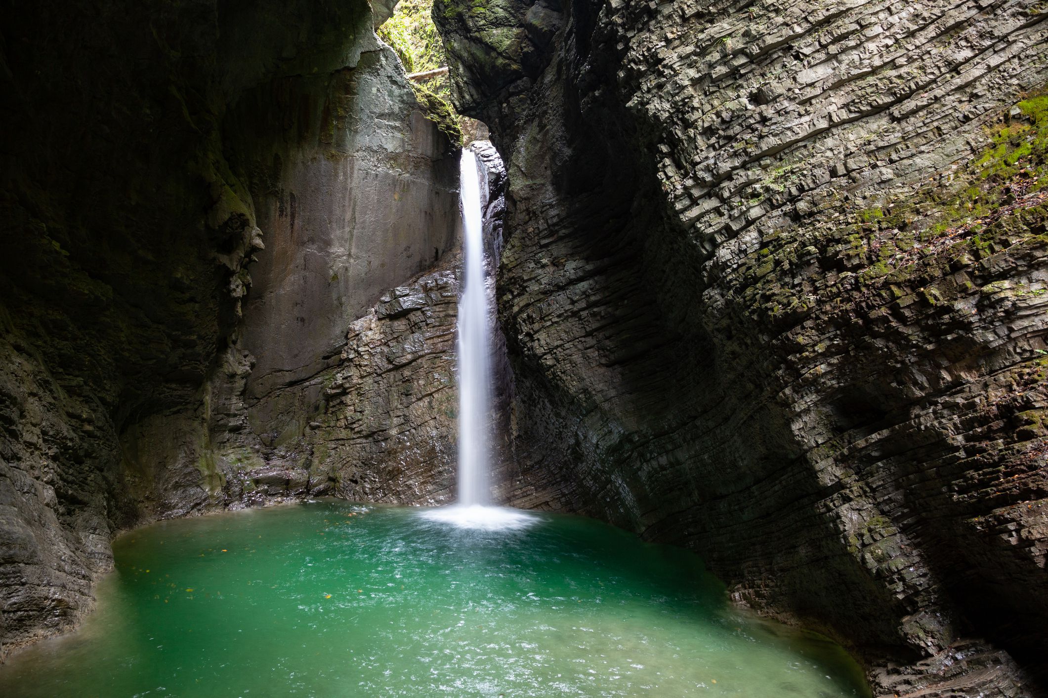 Slide 10 of 52: A 15-meter waterfall splashes down in this mossy, limestone cave near Kobarid, Slovenia.