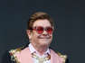 Elton John wearing sunglasses posing for the camera