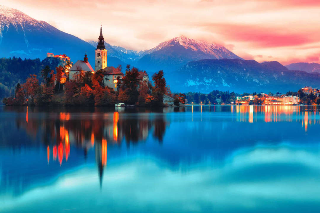 Slide 47 of 58: The already picturesque Lake Bled is enhanced by a church&nbsplocated on an islet. The Julian Alps provide a suitable romantic backdrop.