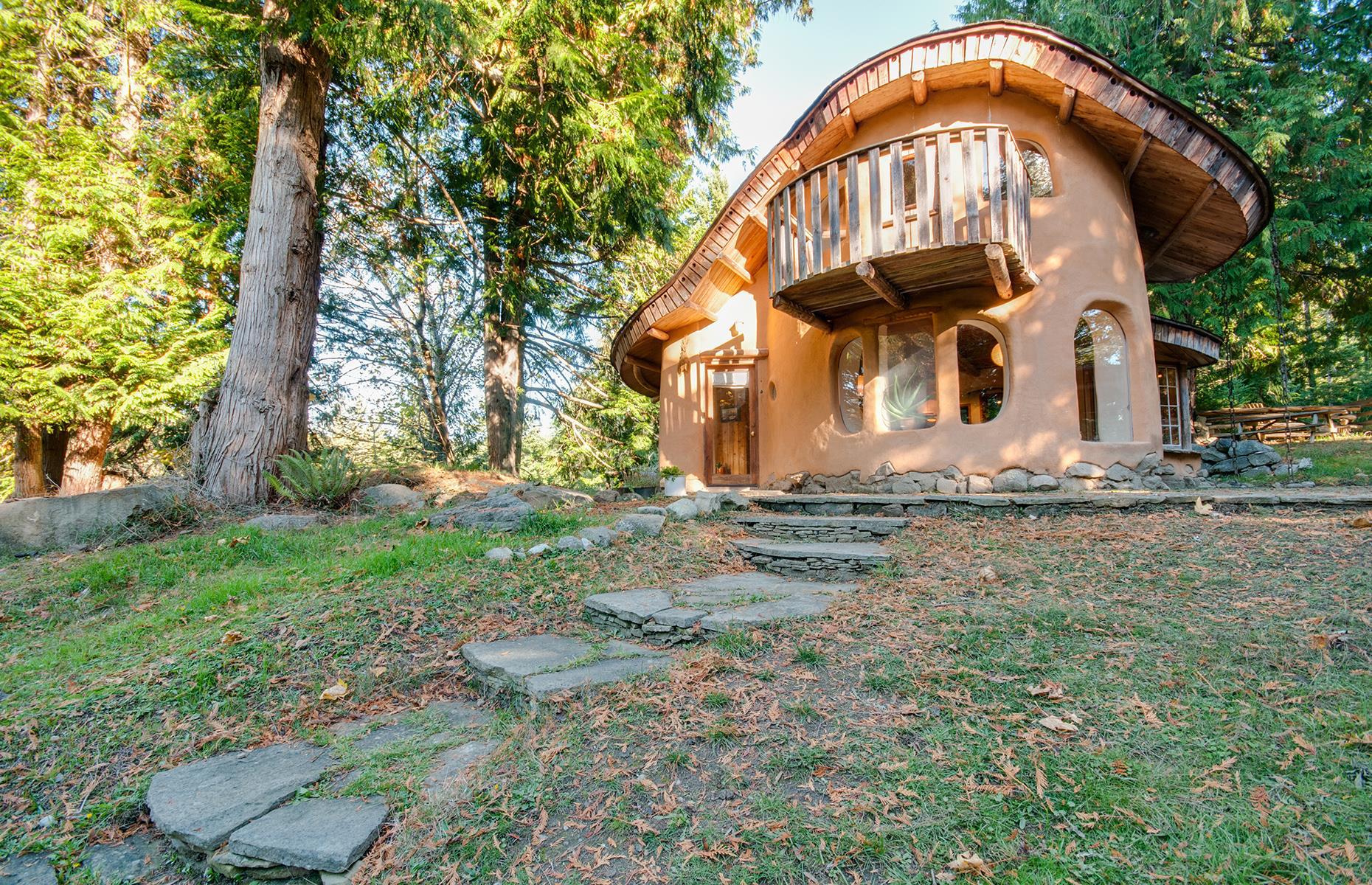 <p><a href="https://www.airbnb.co.uk/rooms/plus/1720832">This cozy cottage's</a> undulating roof, wooden balcony and curved windows could come straight from a fairy tale. The property is hand-sculpted from natural materials and surrounded by orchards with grazing sheep. Inside, it’s every bit as charming with stone floors, a wood-burning stove and wood-clad bedroom. </p>