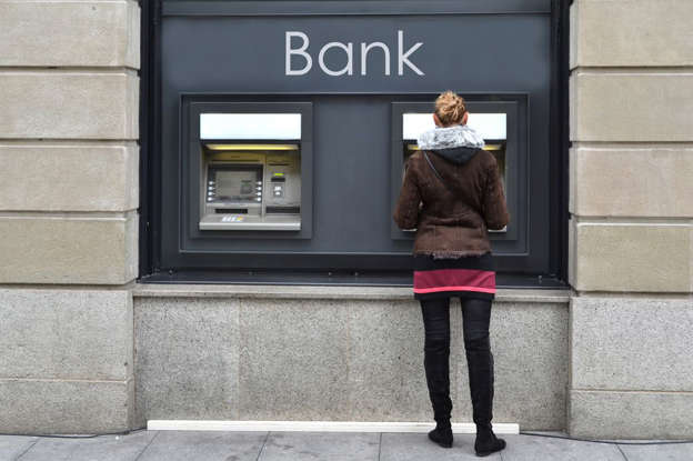 a woman standing in front of a building talking on a cell phone