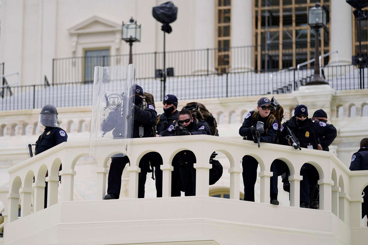 Slide 18 of 76: Police keep a watch on demonstrators who tried to break through a police barrier, Wednesday, Jan. 6, 2021, at the Capitol in Washington. As Congress prepares to affirm President-elect Joe Biden's victory, thousands of people have gathered to show their support for President Donald Trump and his claims of election fraud.
