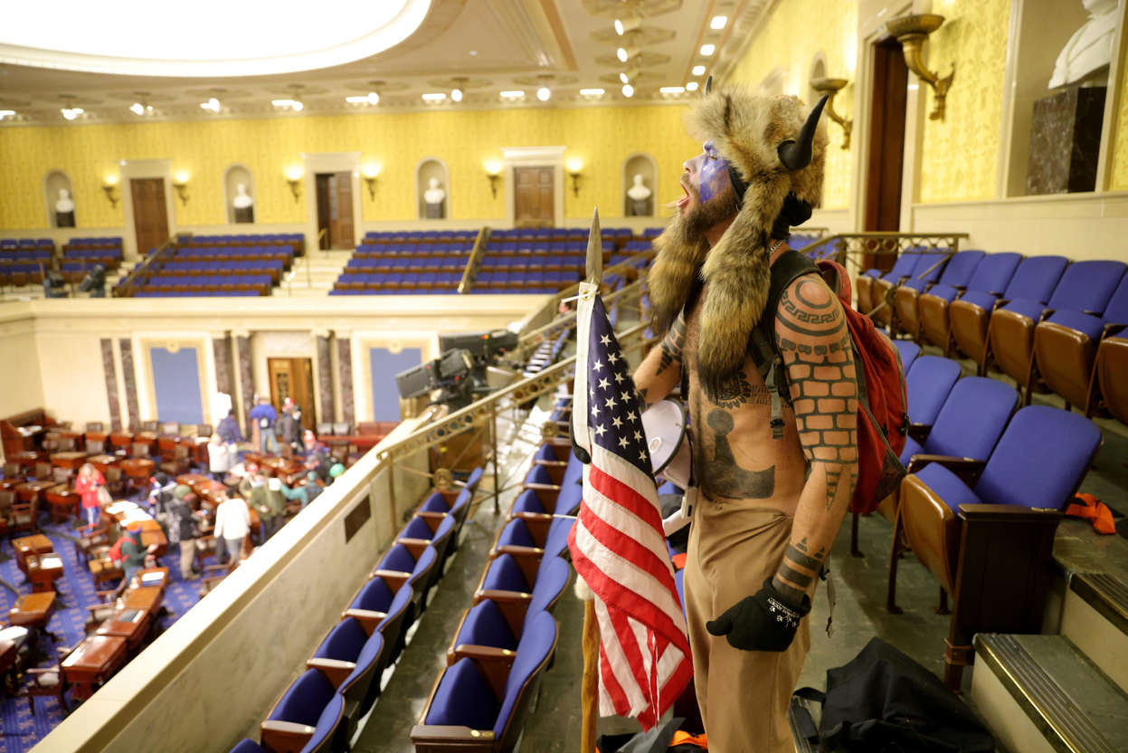 Slide 13 of 76: Jacob Anthony Chansley, aka Jake Angeli of Phoenix, yells inside the Senate chamber on Jan. 6, 2021, in Washington, D.C. Congress held a joint session to ratify President-elect Joe Biden's 306-232 Electoral College win over President Donald Trump. Pro-Trump protesters entered the U.S. Capitol during mass demonstrations in the nation's capital.