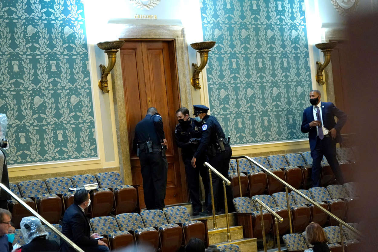 Slide 26 of 76: U.S. Capitol Police draw their guns as protesters attempt to enter the House Chamber during a joint session of Congress on January 06, 2021 in Washington, DC.