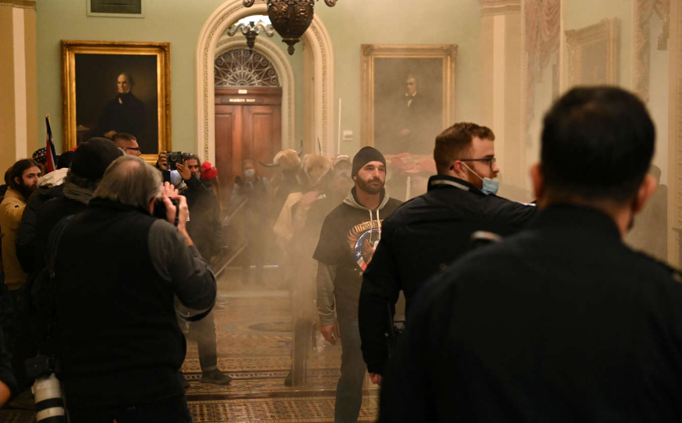 Slide 33 of 76: Supporters of US President Donald Trump enter the US Capitol as smoke fills the corridor on January 6, 2021, in Washington, DC. There are no reports of tear gas being used at the Capitol.