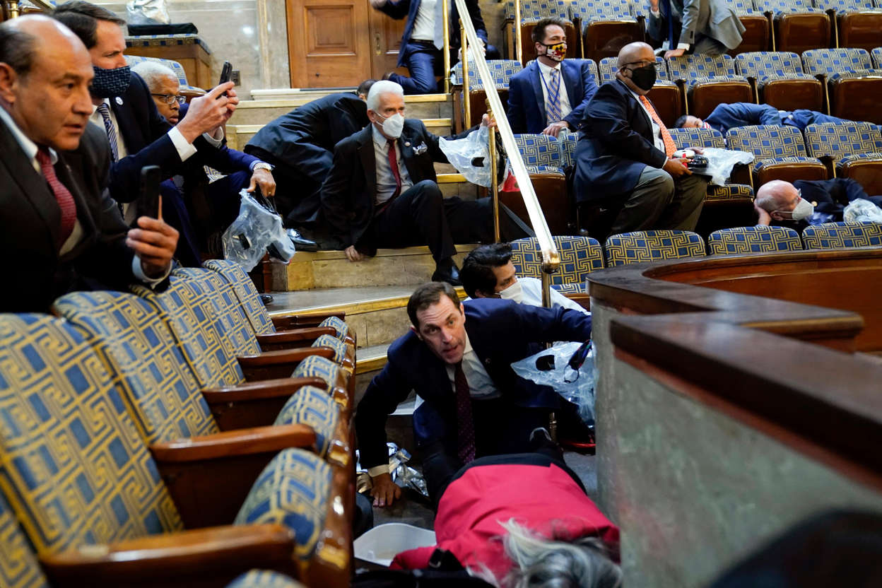 Slide 30 of 76: People shelter in the House gallery as Pro-Trump rioters try to break in at the U.S. Capitol on Jan. 6.