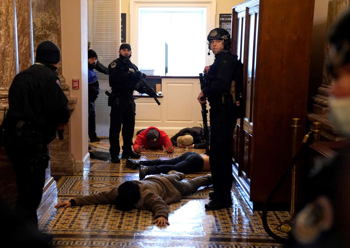 Slide 23 of 76: U.S. Capitol Police stand detain protesters outside of the House Chamber during a joint session of Congress on January 06, 2021 in Washington, DC.